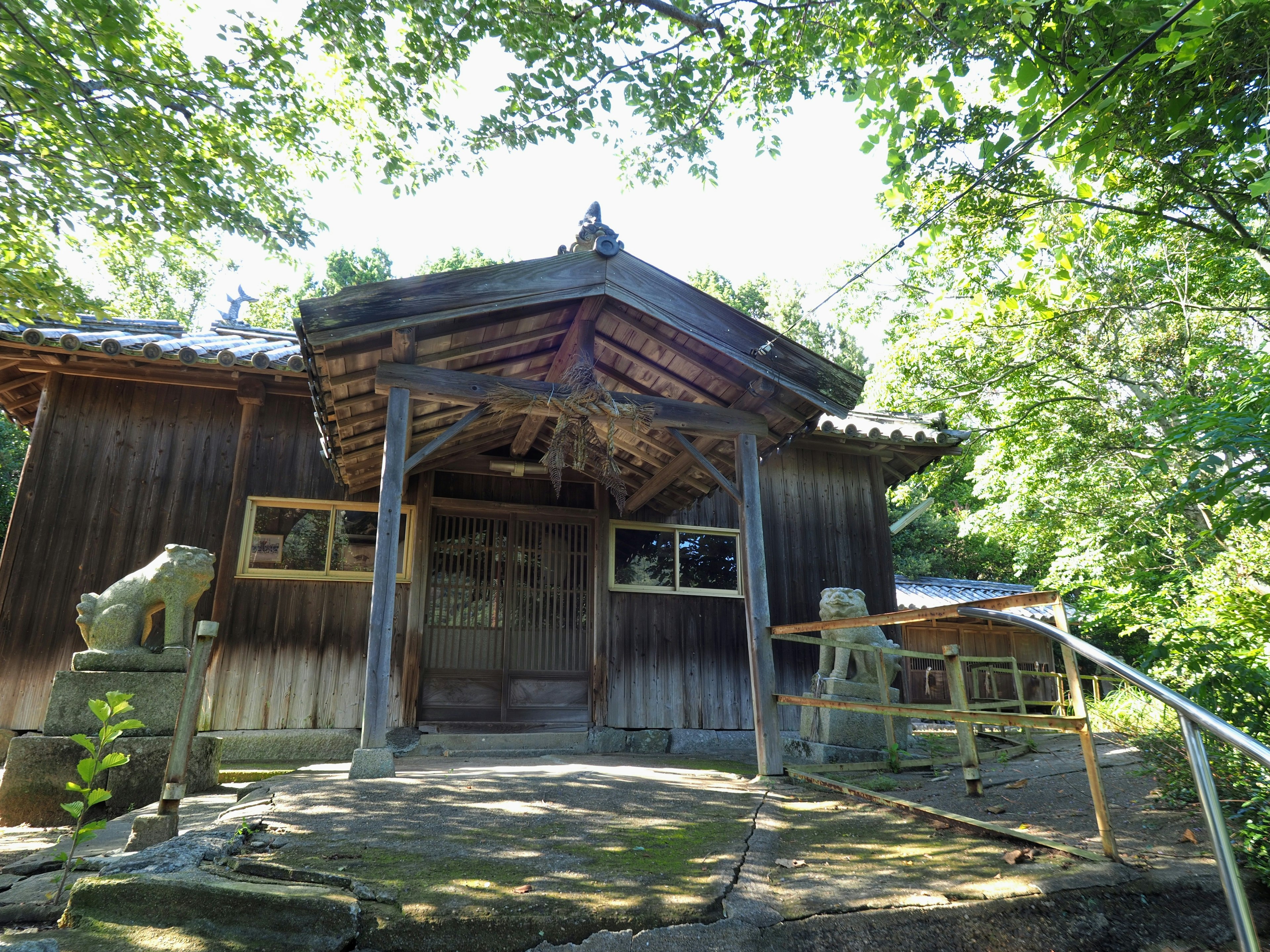 Extérieur d'une maison japonaise traditionnelle en bois entourée de verdure luxuriante