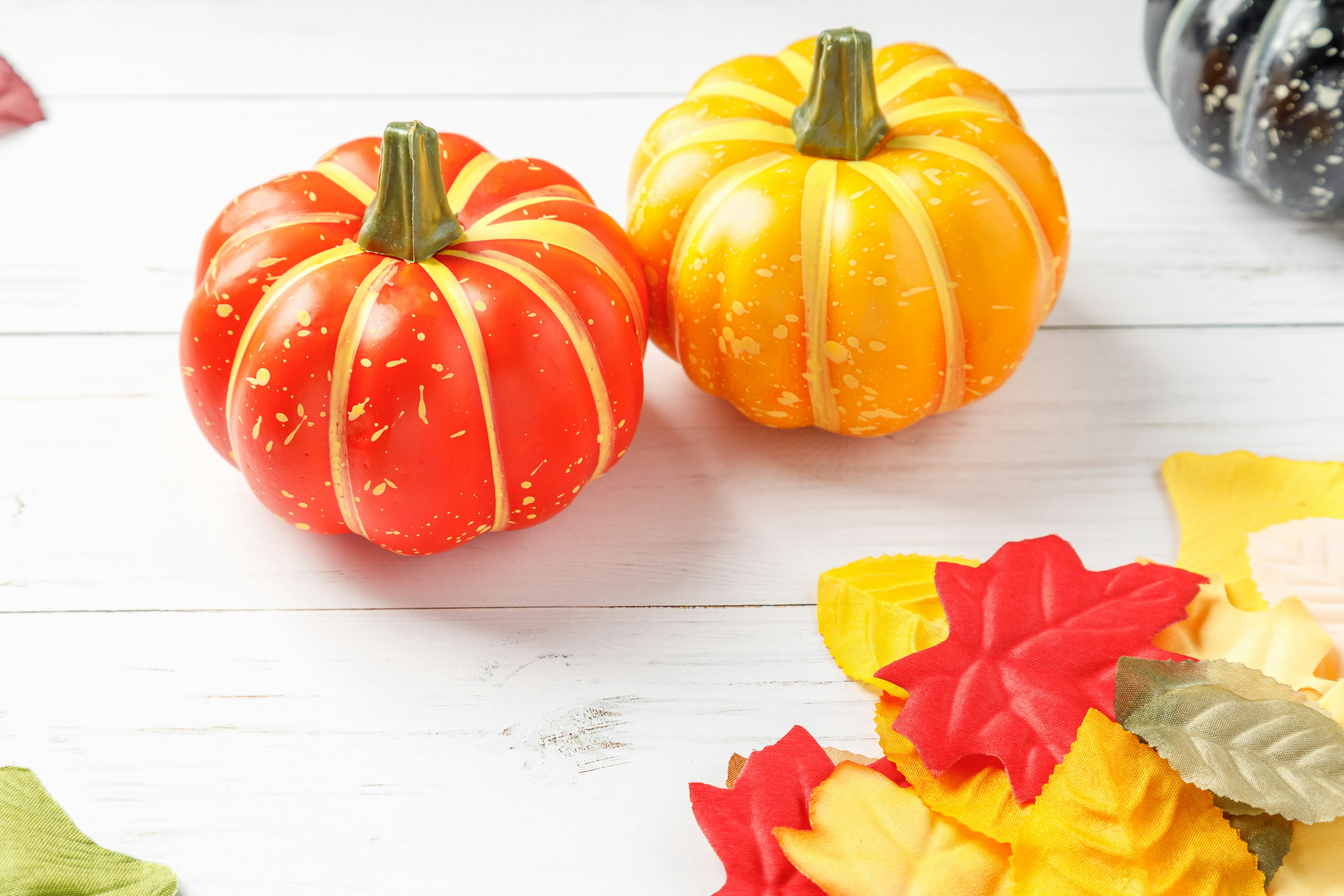 Decorative red and yellow pumpkins with colorful leaves for autumn