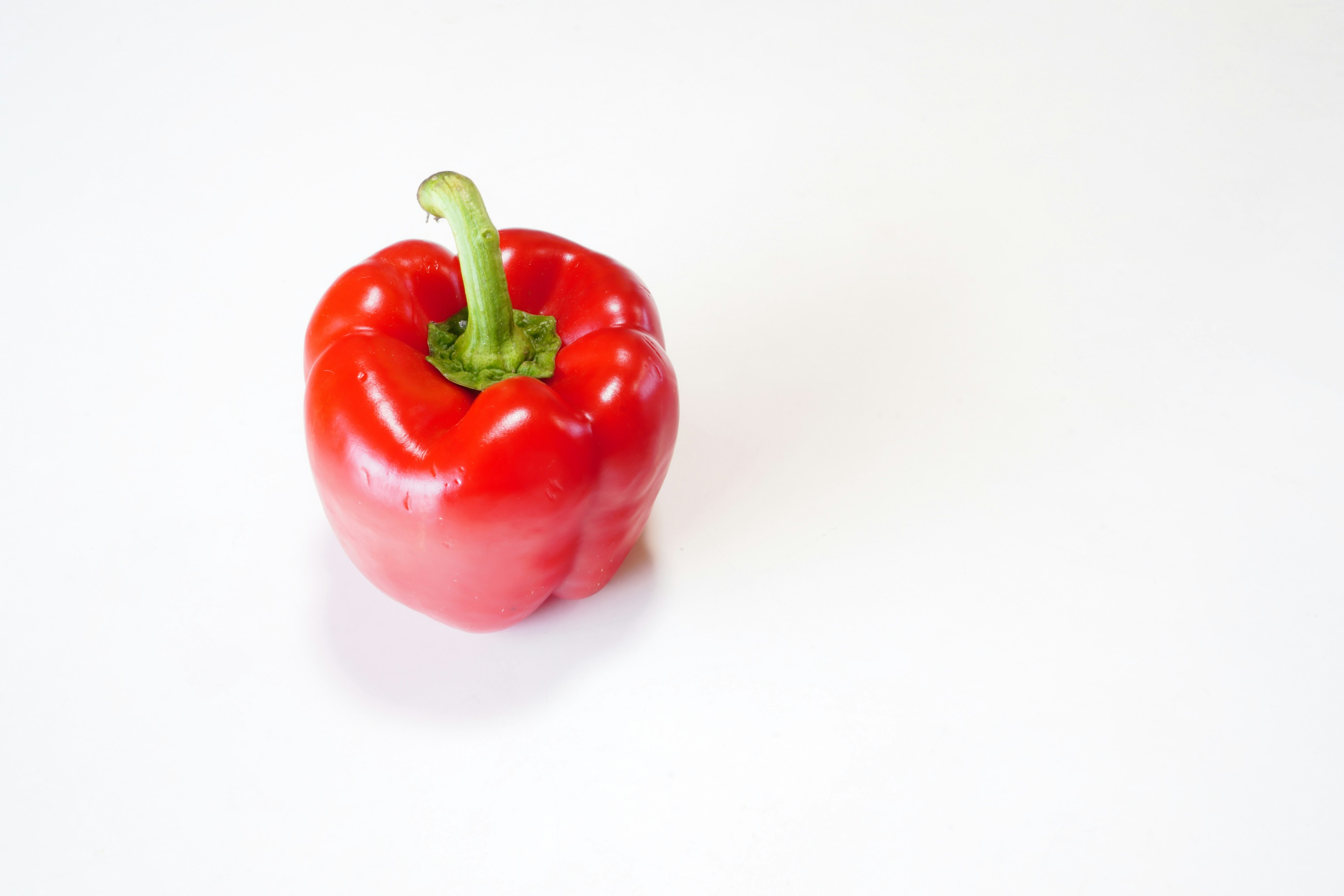 A red bell pepper placed on a white background