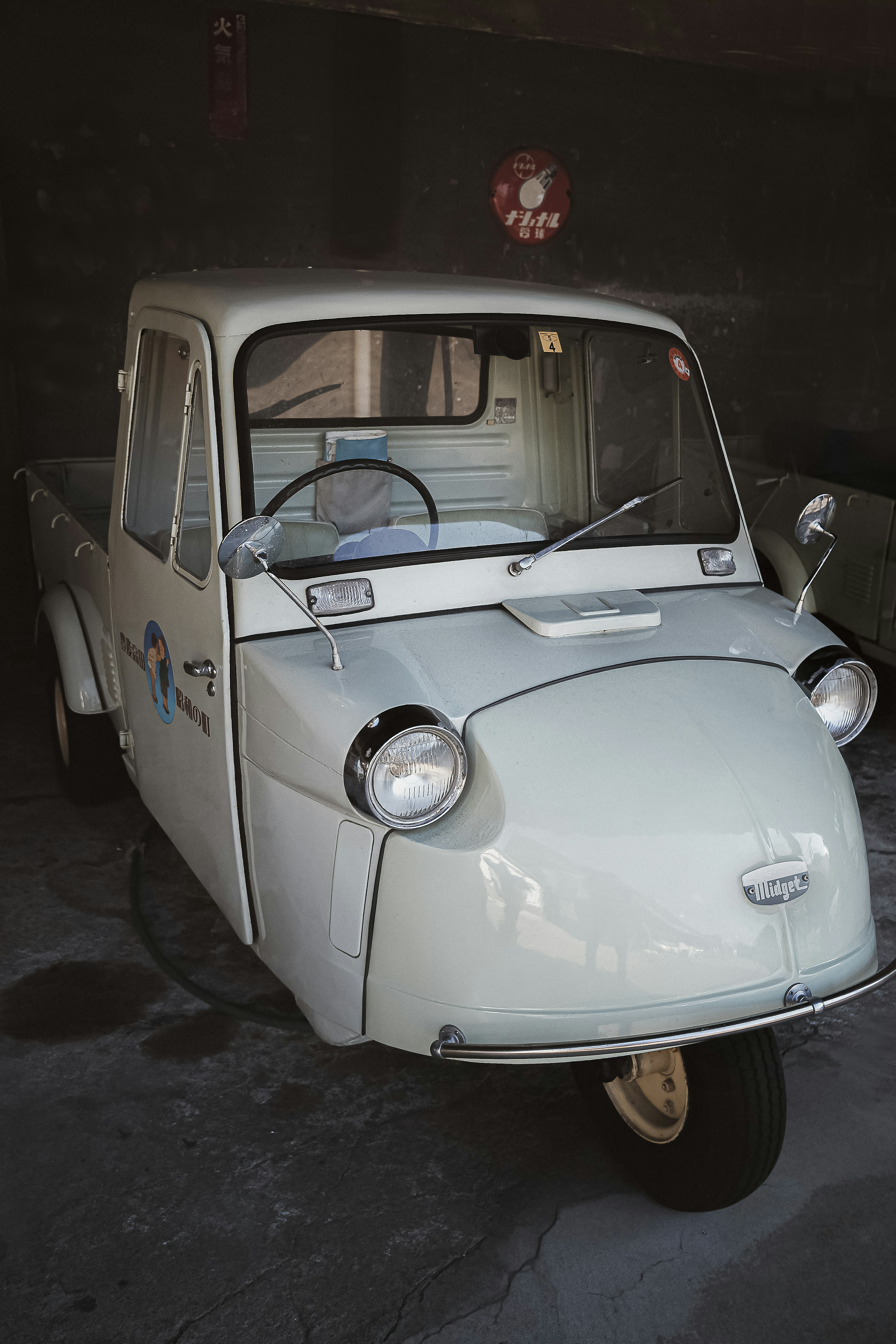 Ein kleines weißes Lastwagen-ähnliches Fahrzeug steht in einer Garage