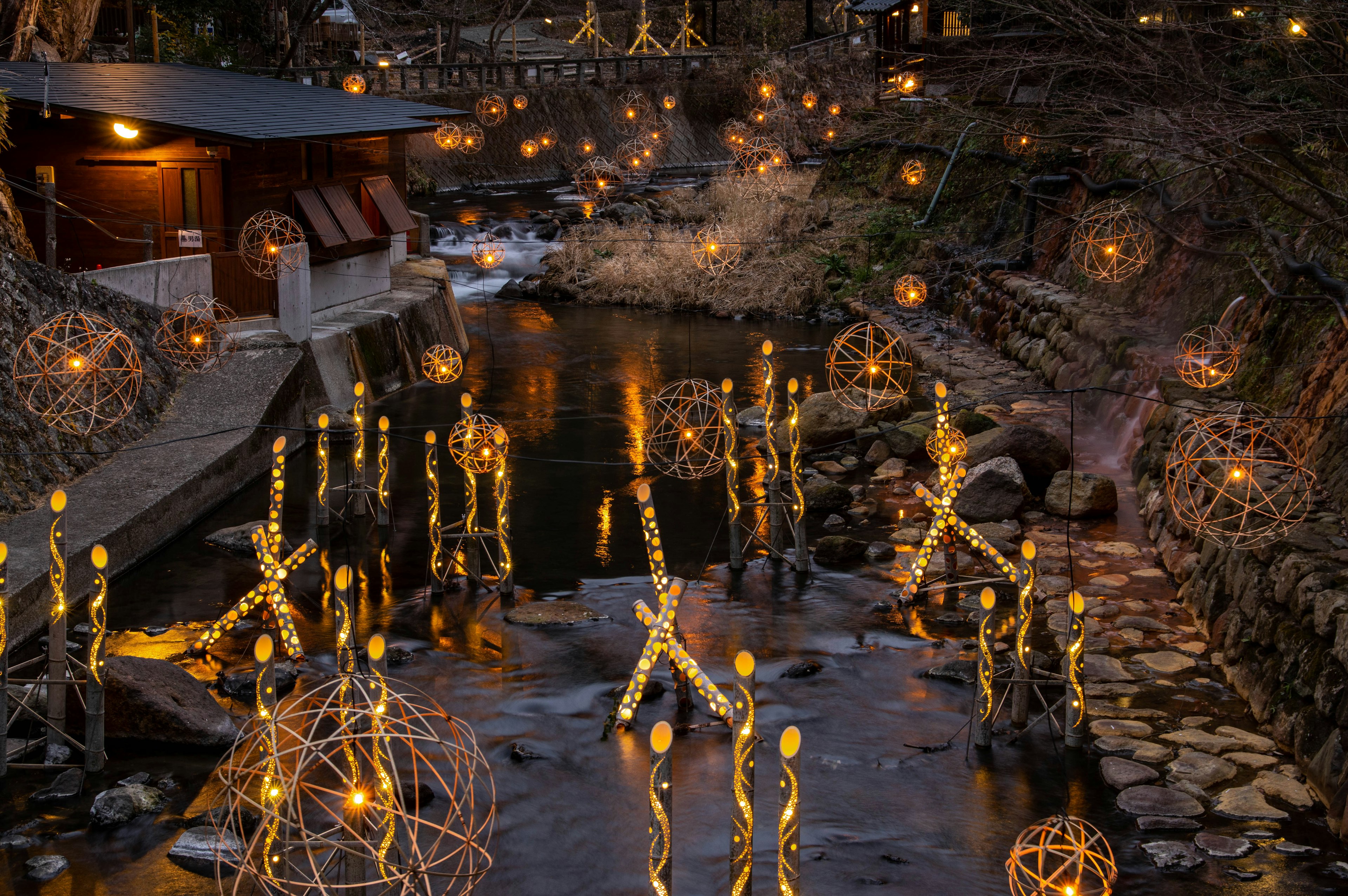 Vue pittoresque d'orbes lumineux et de décorations illuminées le long d'une rivière