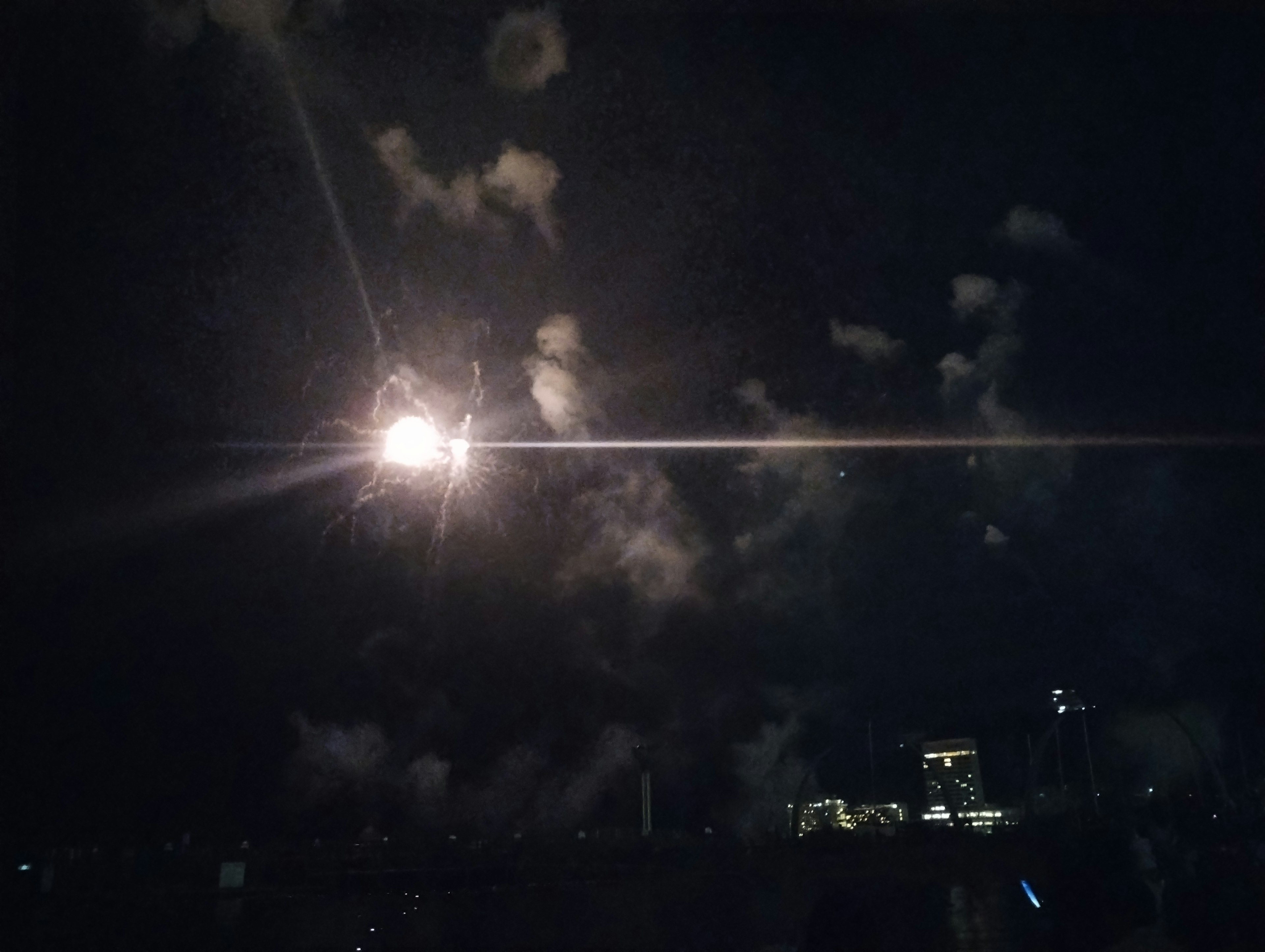 Lumière brillante dans le ciel nocturne avec des silhouettes de nuages