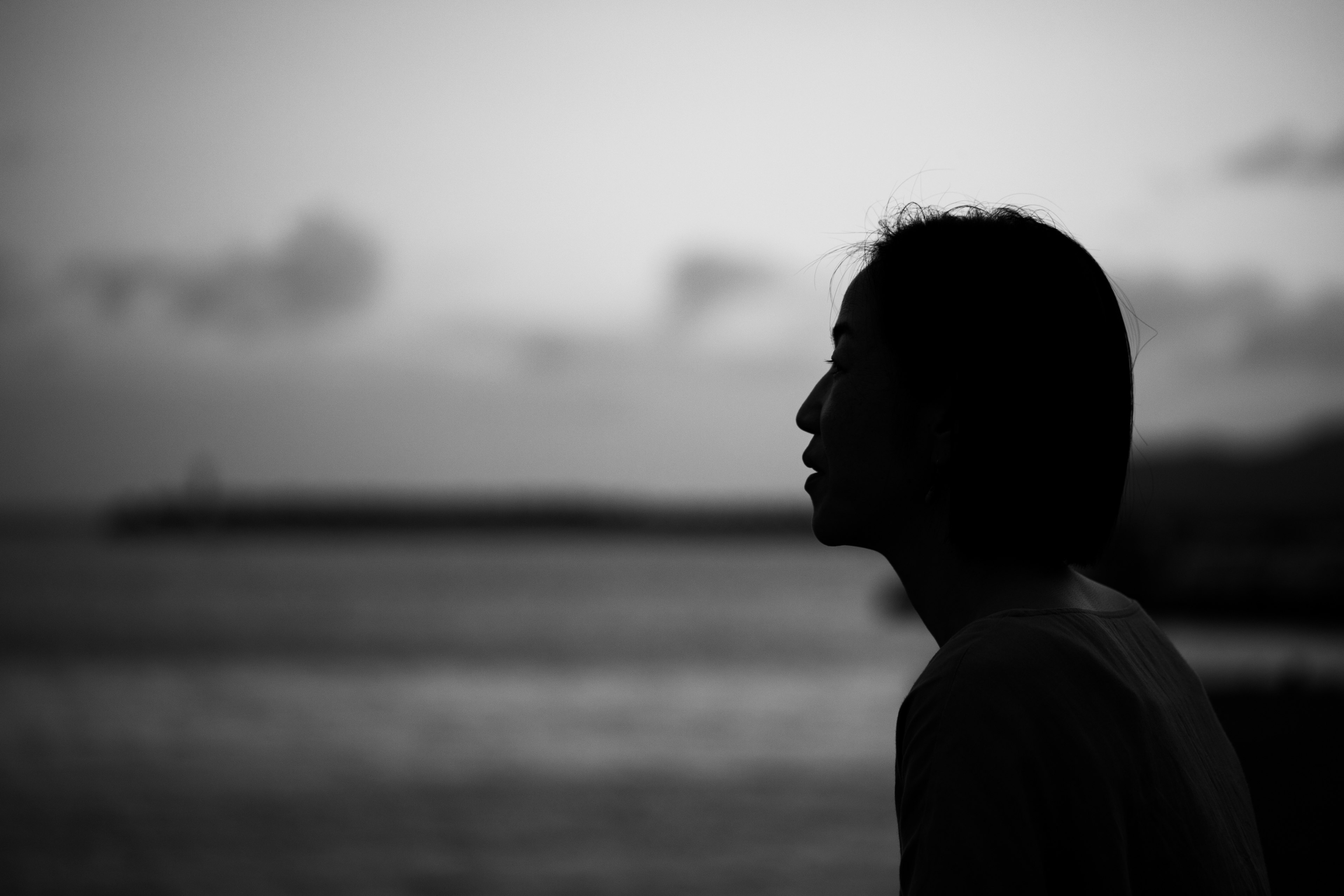 Silhouette di una persona al mare in bianco e nero