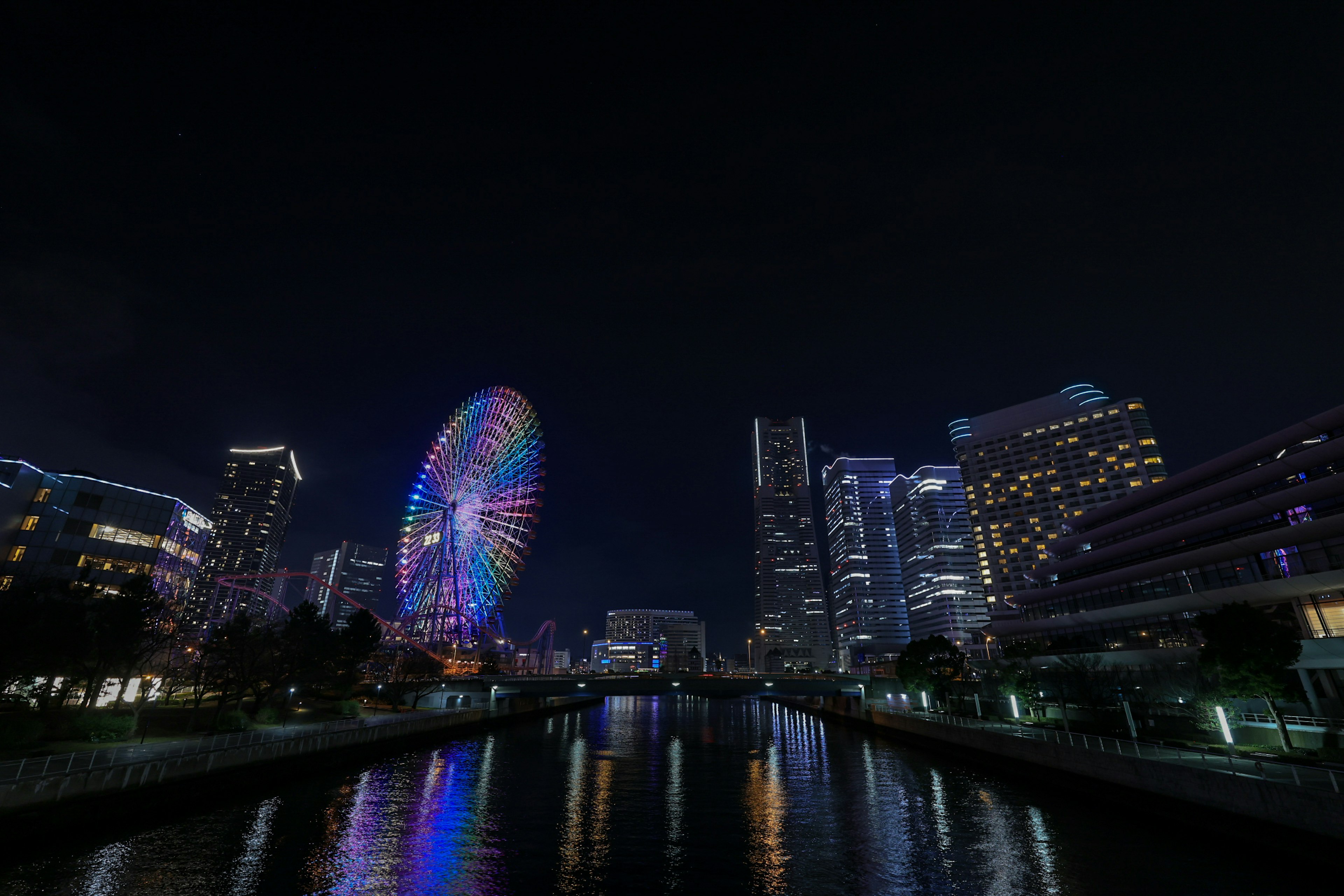 夜景の観覧車と高層ビルが映る川の風景