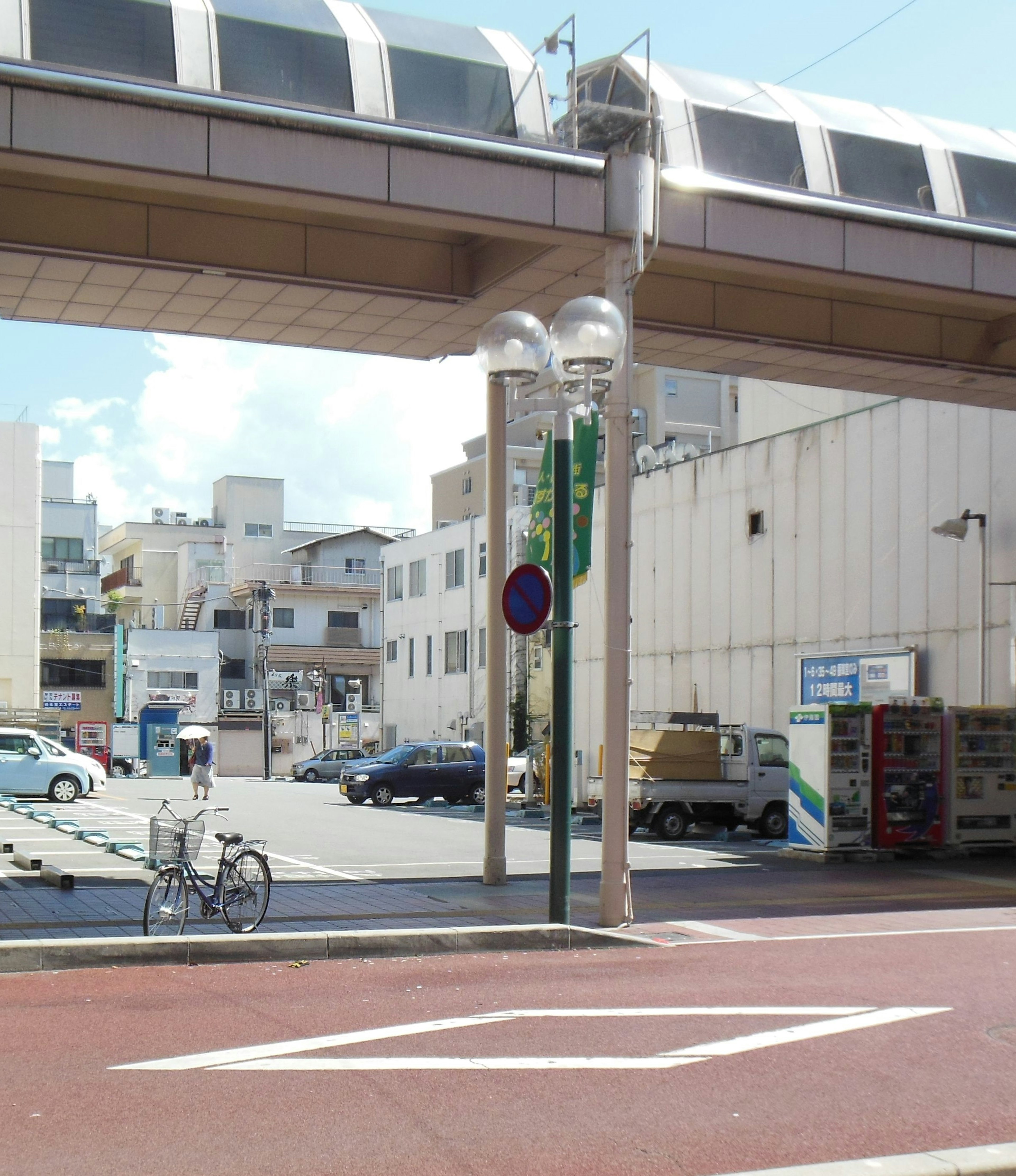 Szene eines Parkplatzes und eines Fahrrads unter einer erhöhten Bahn