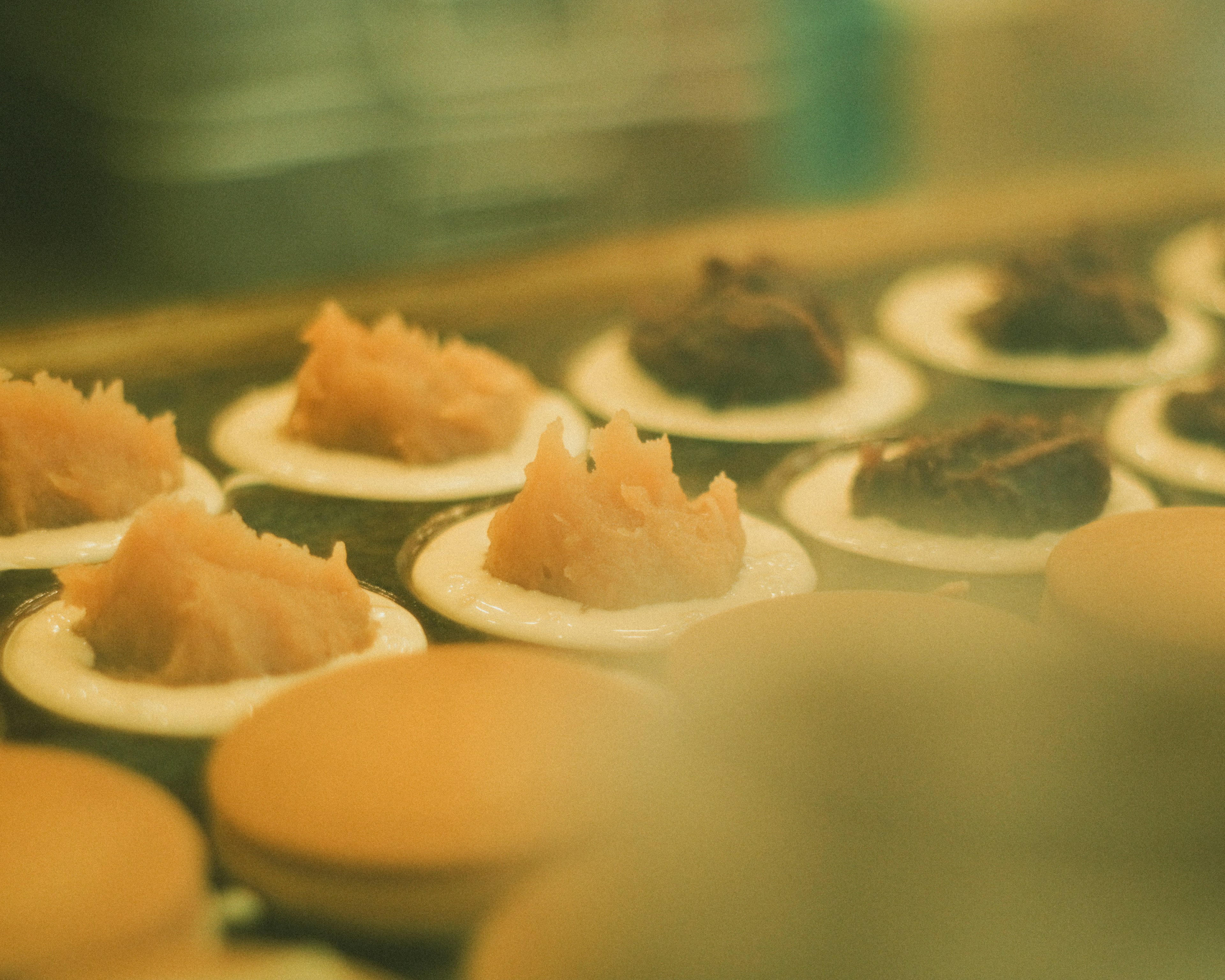 Rows of baked goods topped with colorful cream