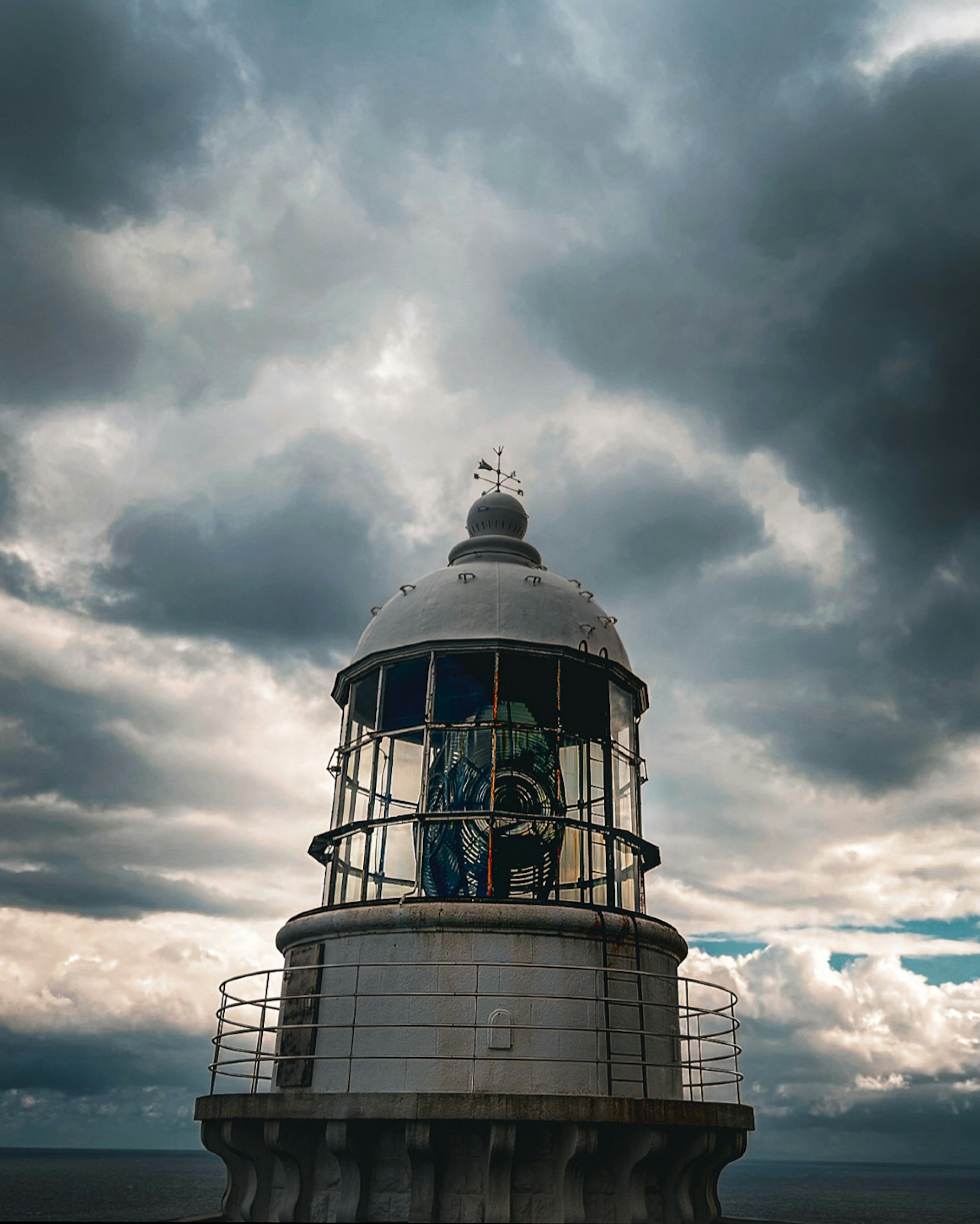 Una torre de faro bajo un cielo nublado dramático