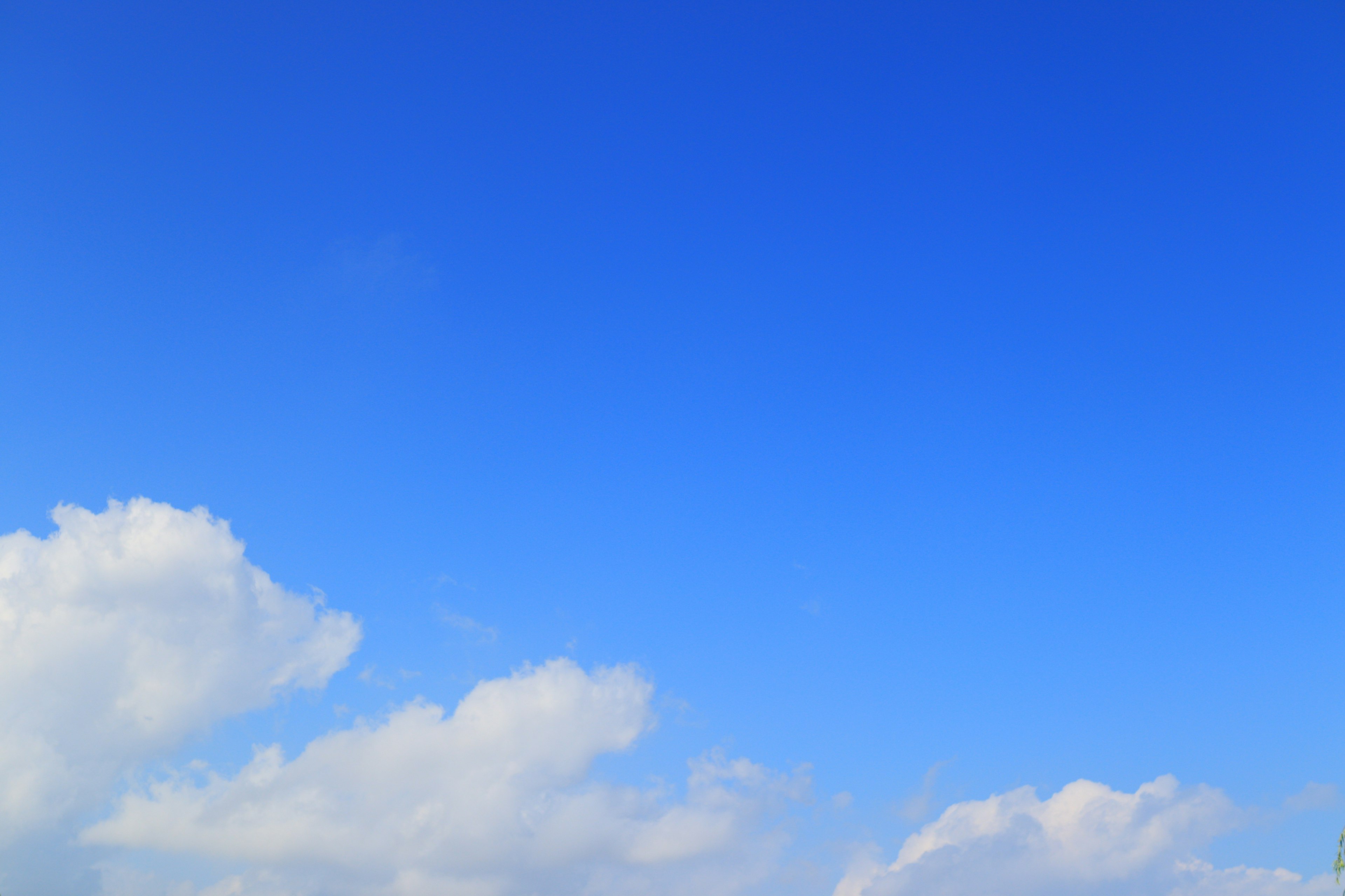 Heller blauer Himmel mit flauschigen weißen Wolken