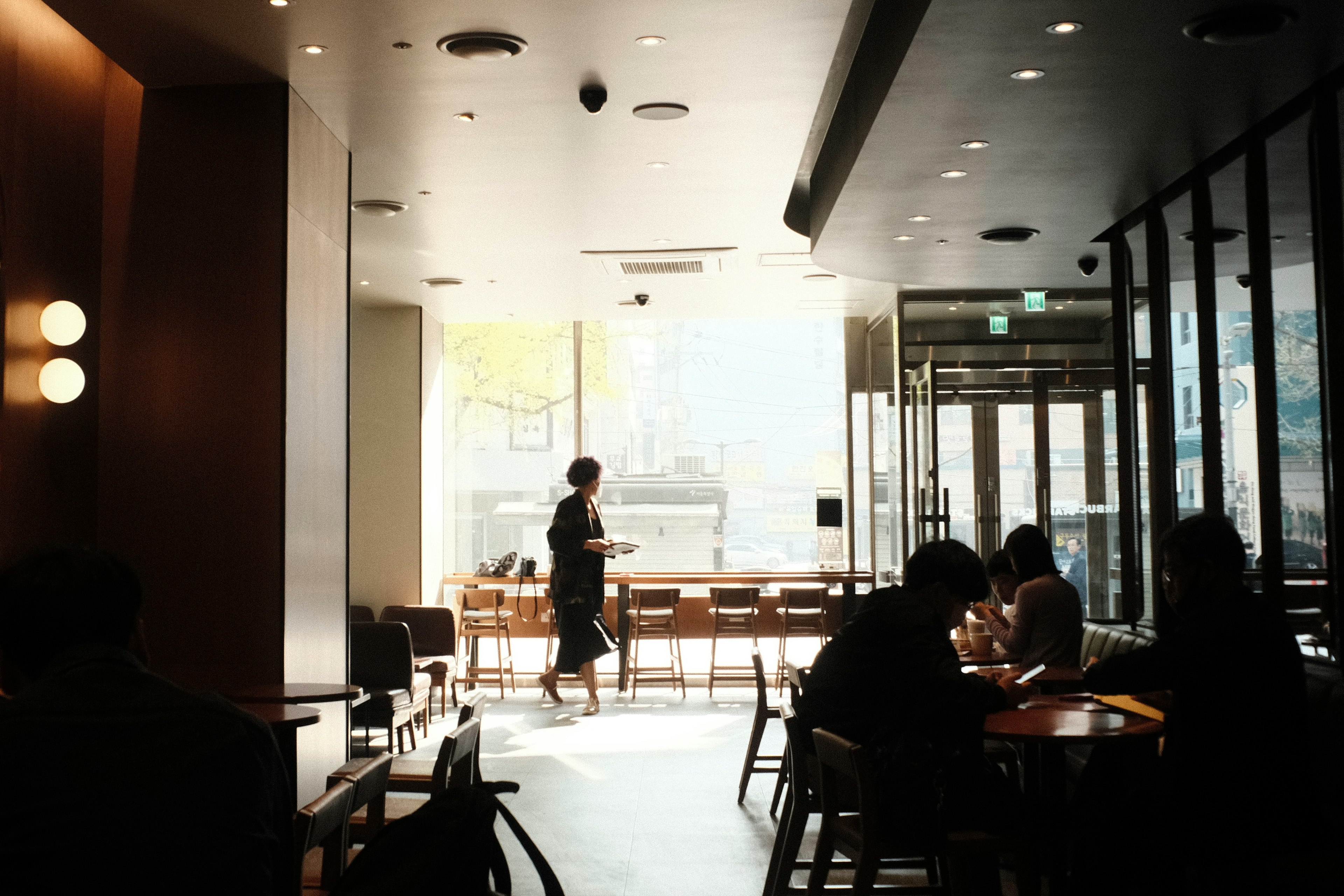 Interior of a cafe with people seated and bright natural light coming in