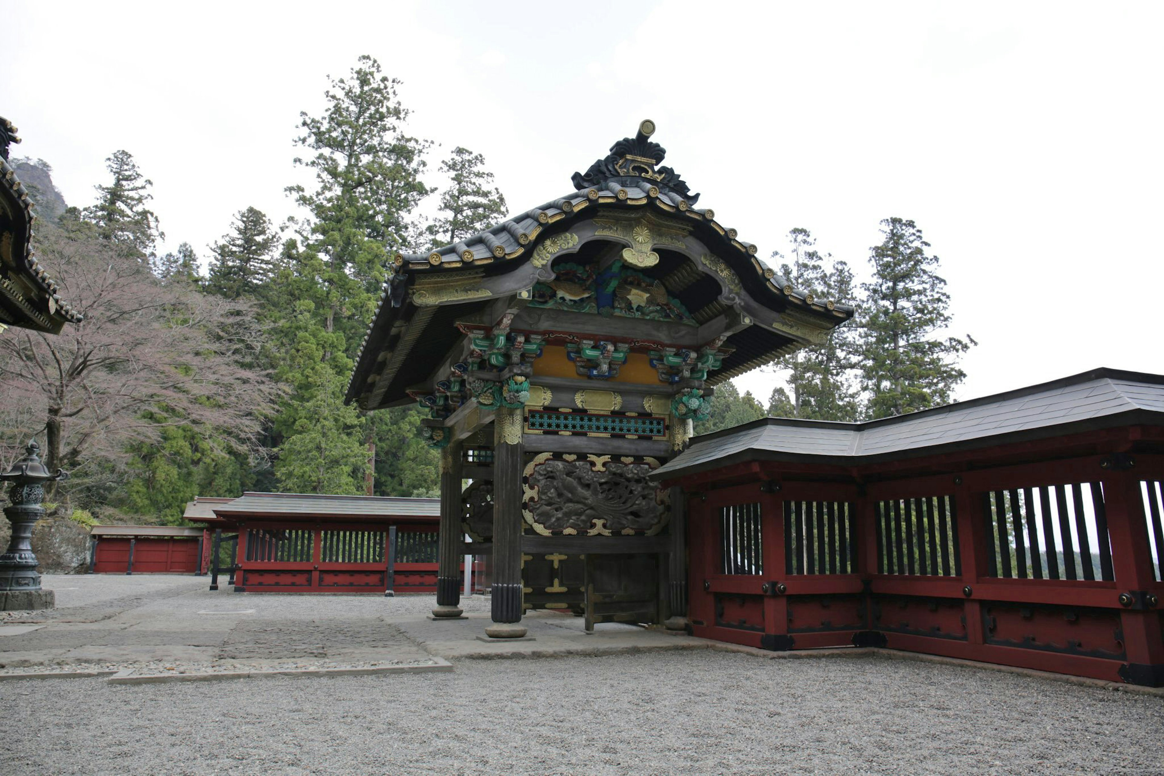 Vibrant shrine gate with red building in a tranquil landscape