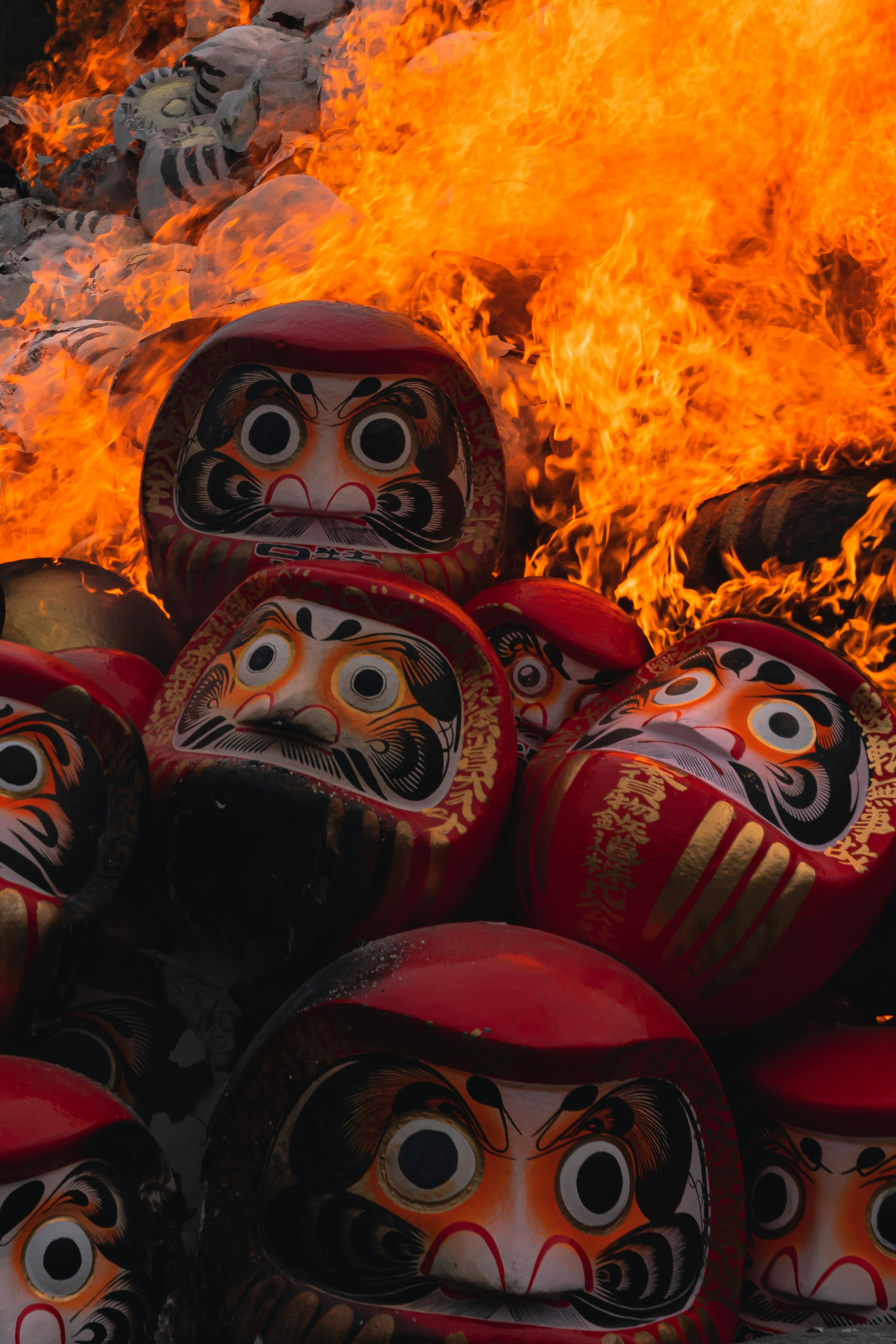 Daruma dolls stacked amidst flames