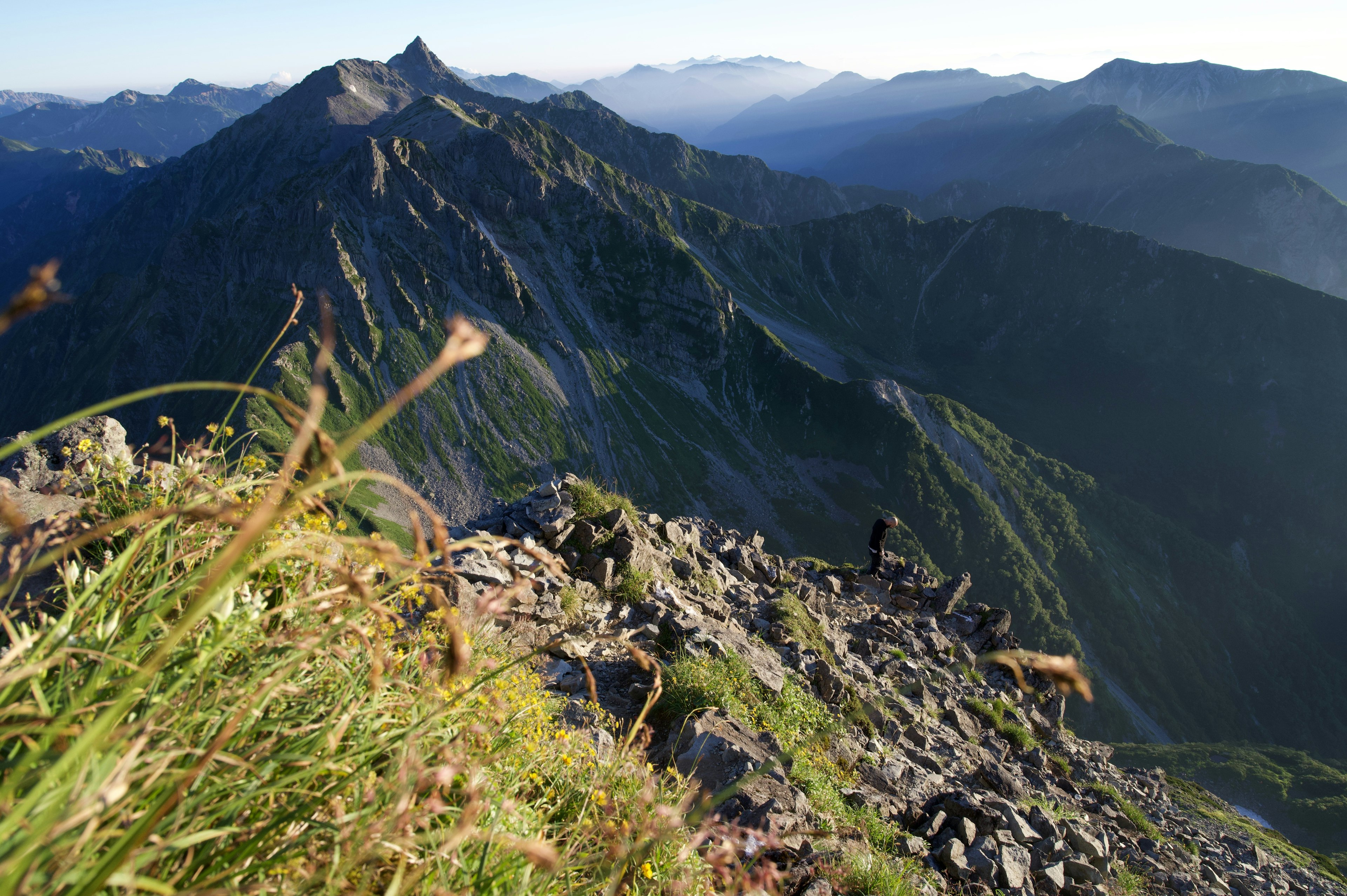 Stunning landscape featuring mountains with grass and rocks in the foreground