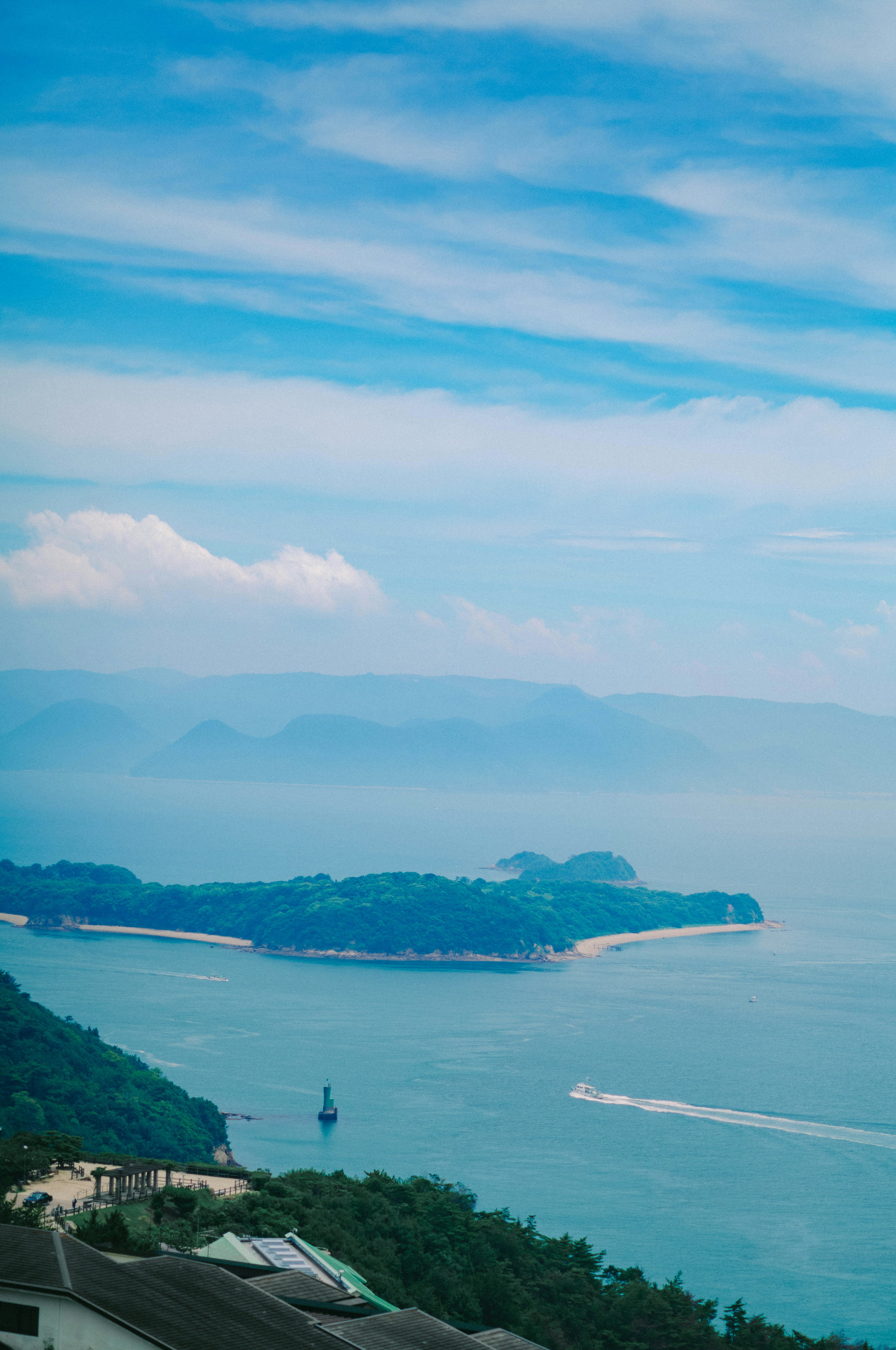 青い海と空の風景に浮かぶ島々と白い雲