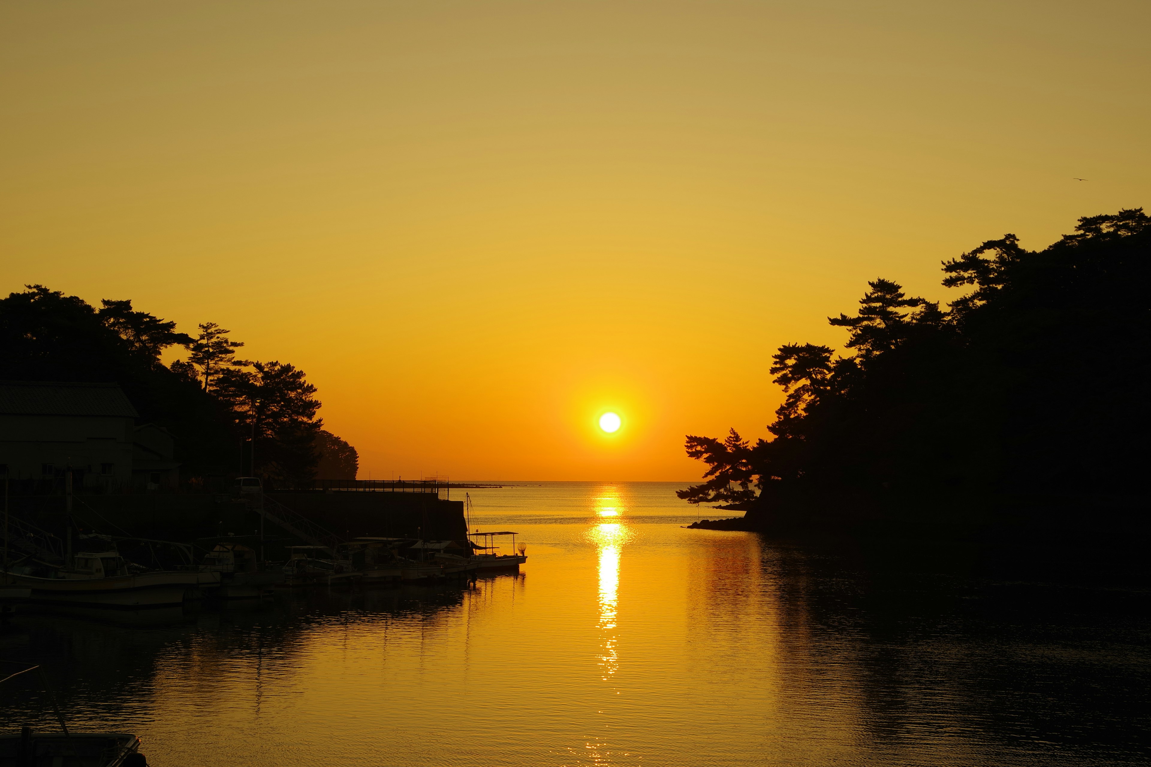 Serene coastal landscape with sunset reflecting on the water