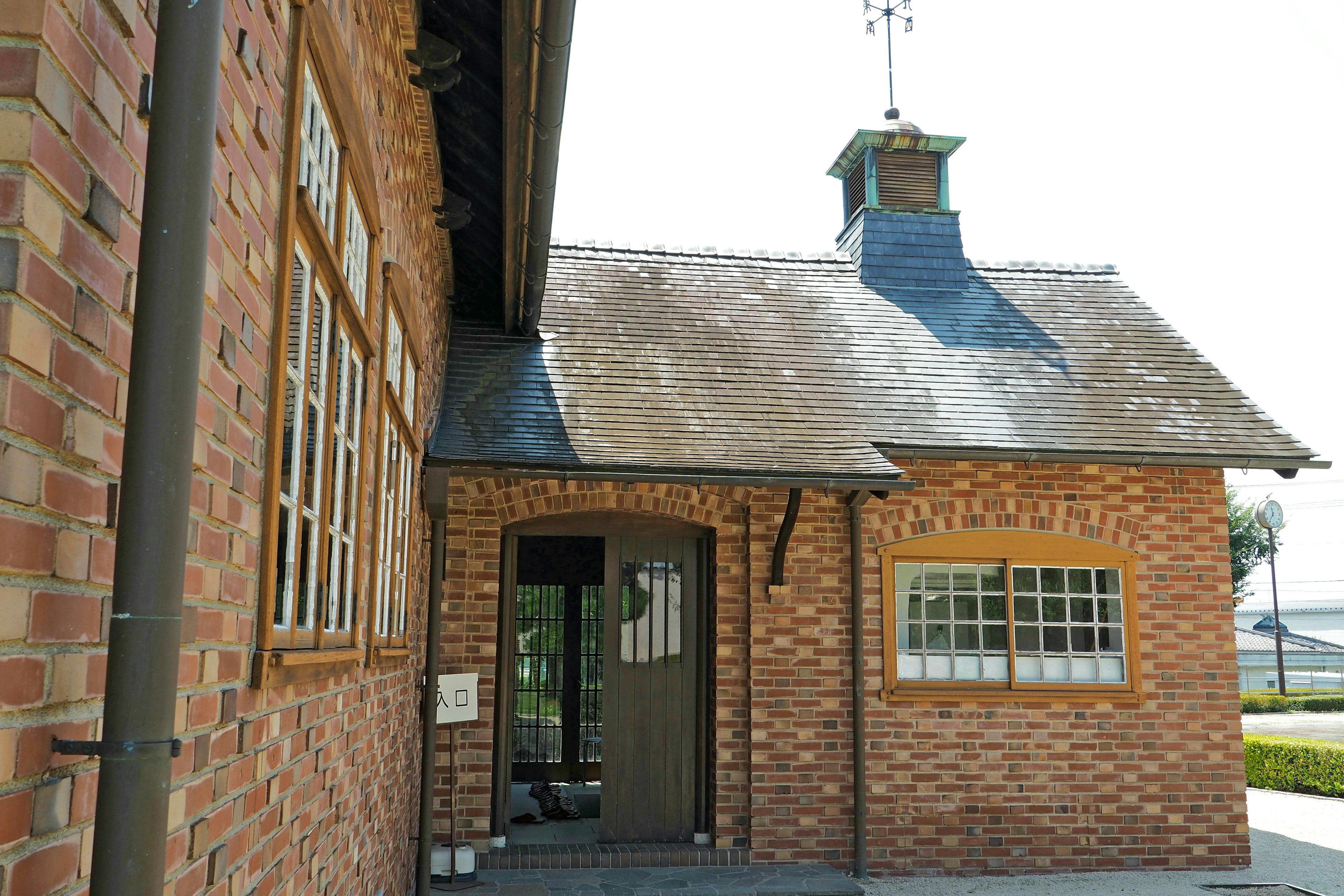 Brick building with a sloped roof and a weather vane