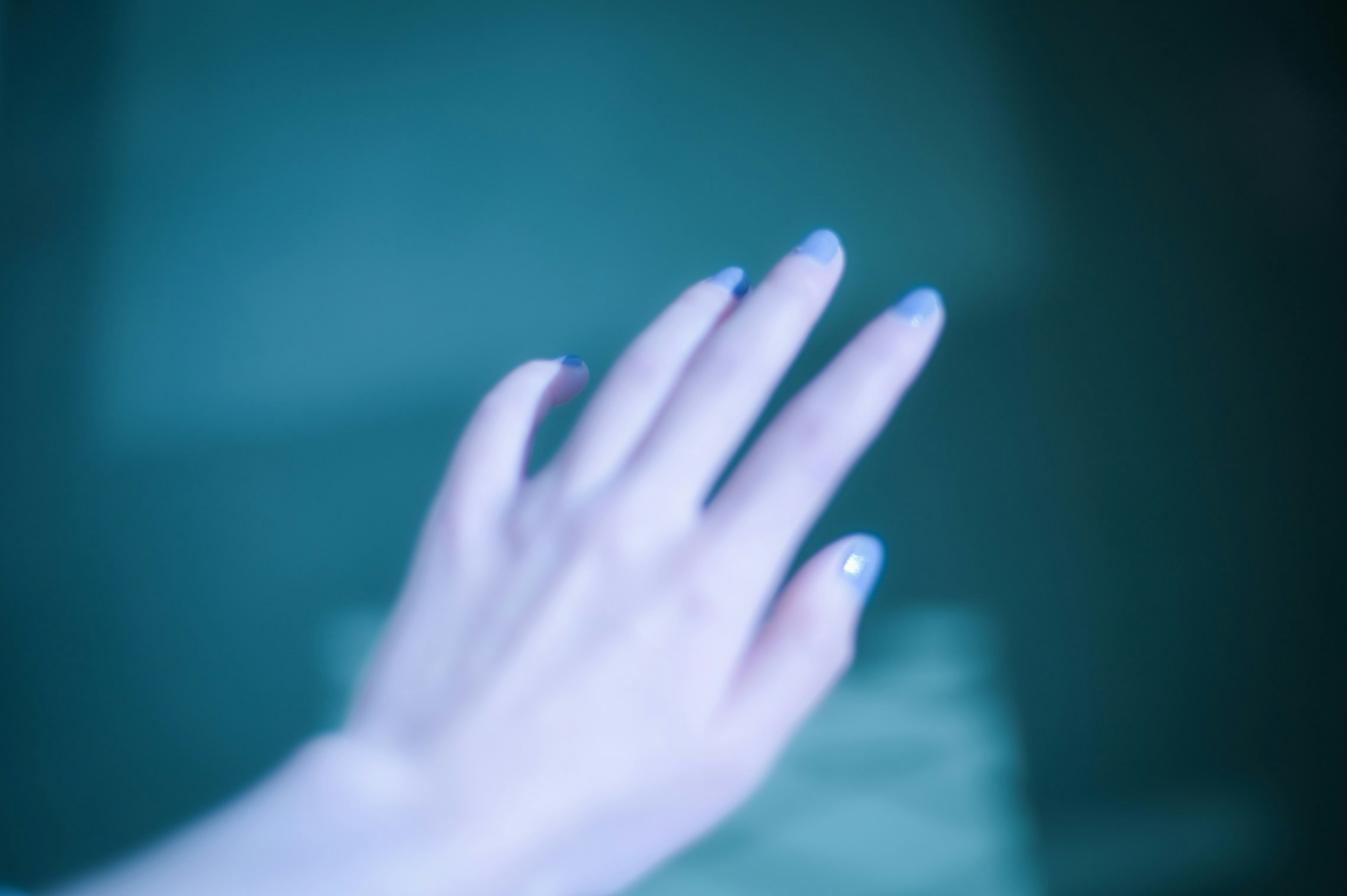 A hand reaching out in blue light