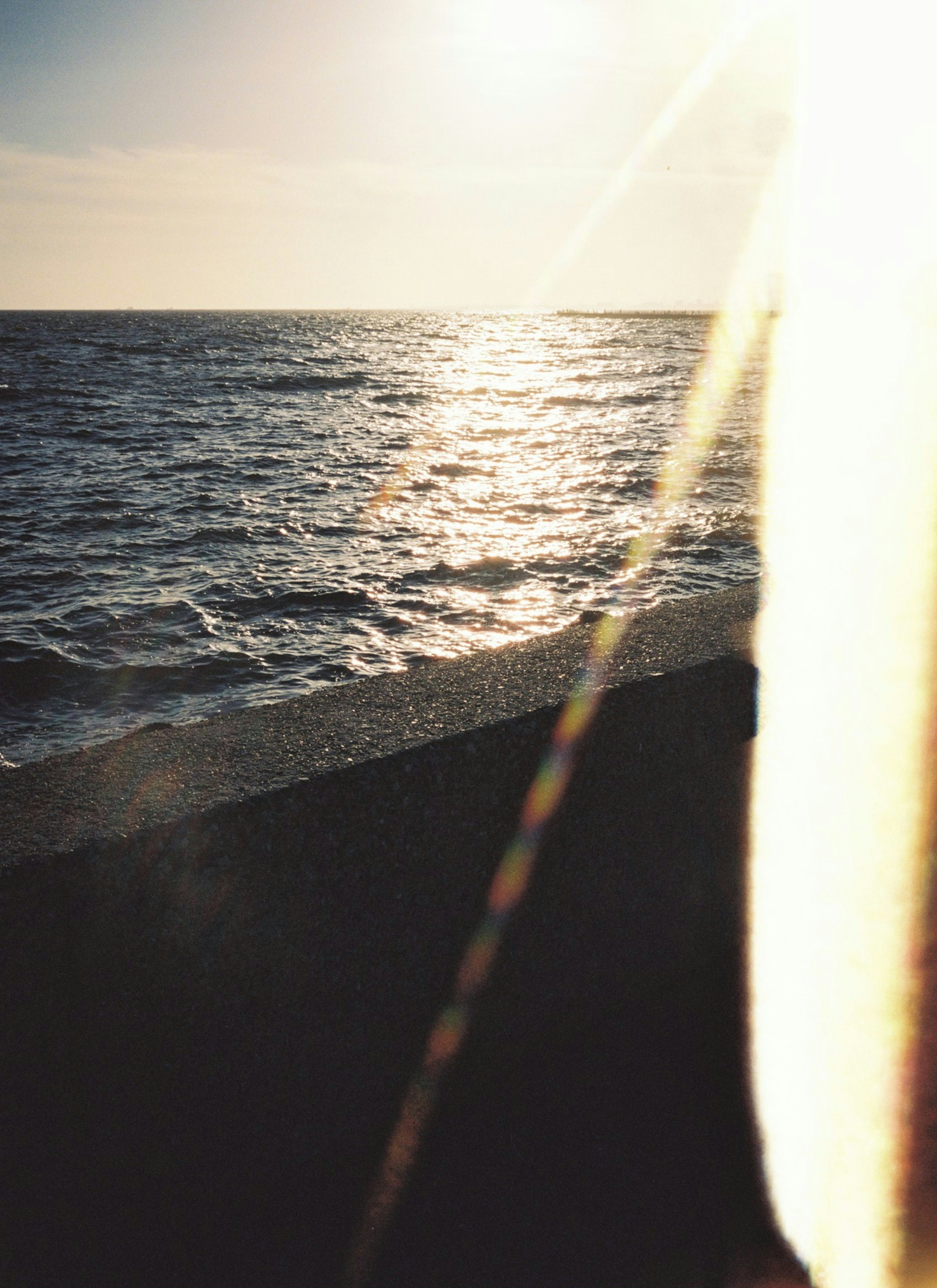 Imagen que captura la vista del mar con reflejos del atardecer