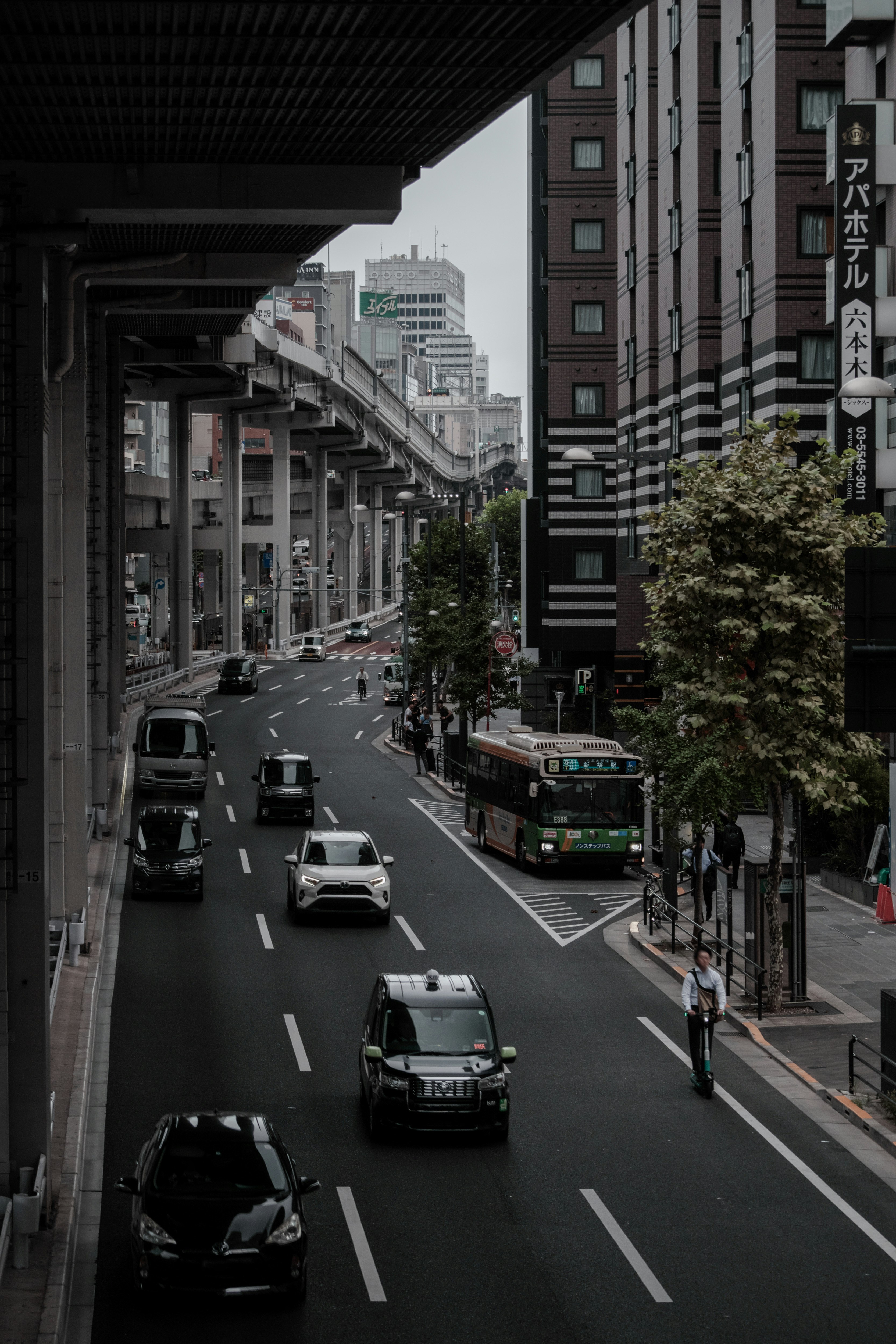 Urban street scene with vehicles and elevated road