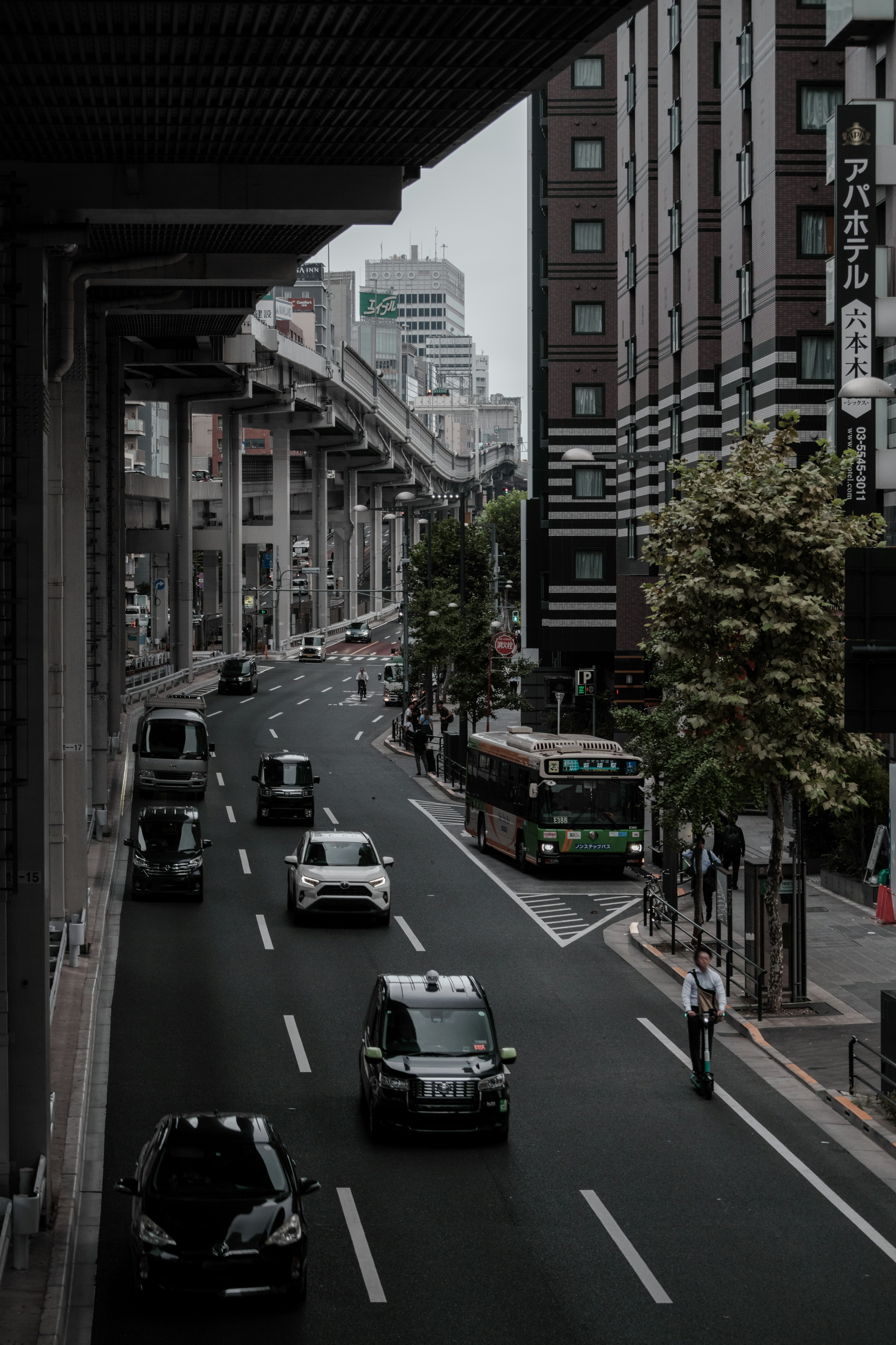 都会の通りに沿った車両と高架道路の風景