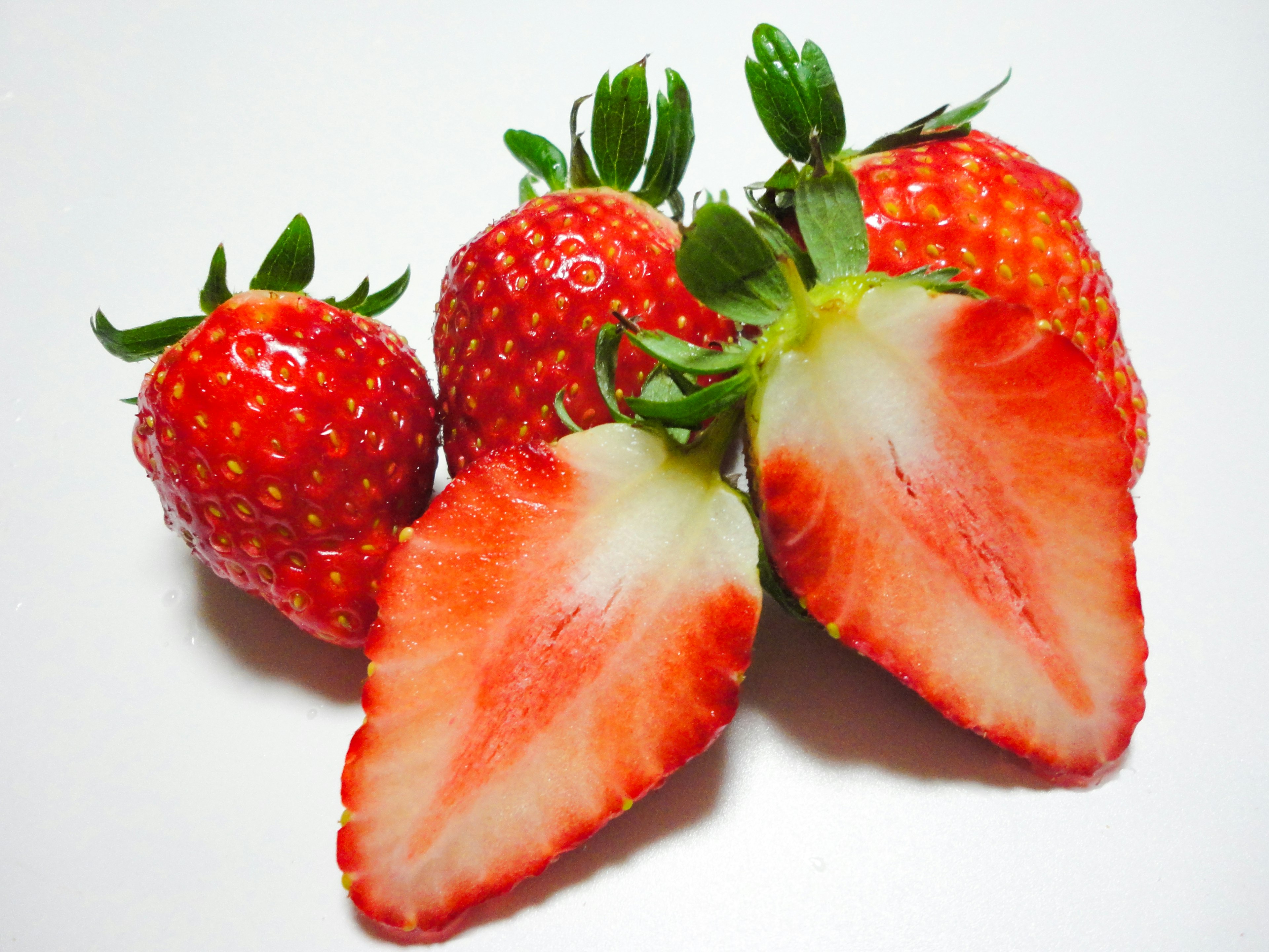 Fresas frescas con una fresa cortada mostrando su interior