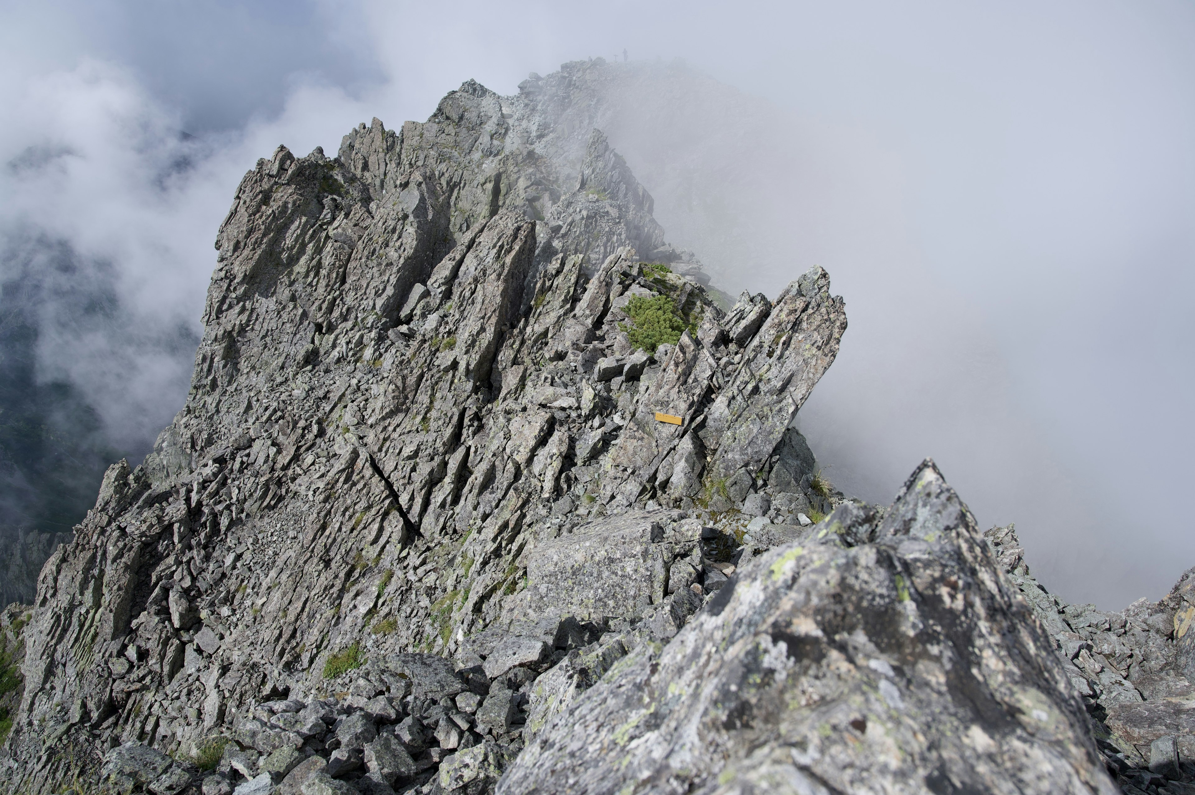 Un pico montañoso rocoso rodeado de nubes