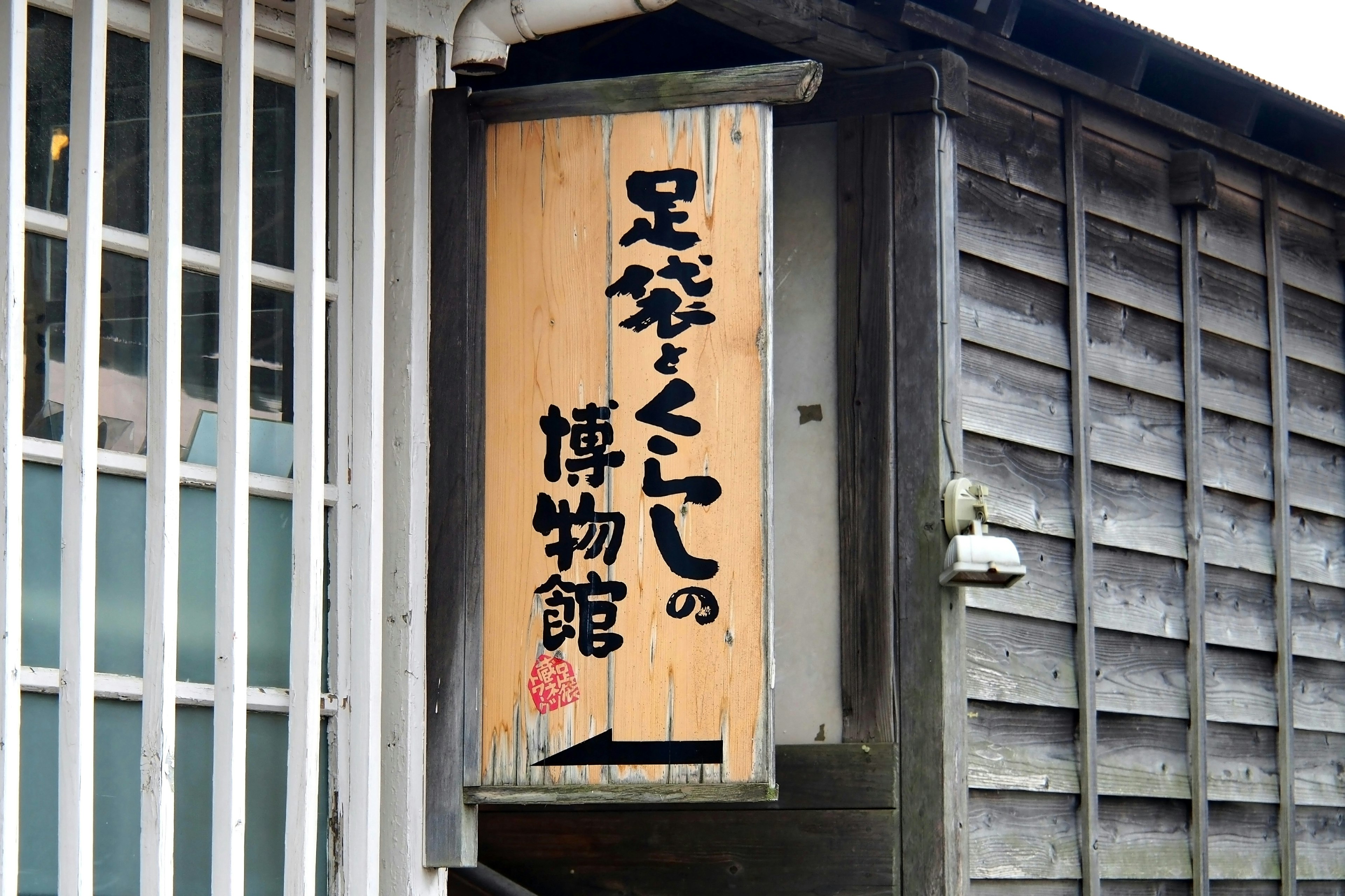 Sign for the Tabi and Kutsu Museum hanging on a wooden wall