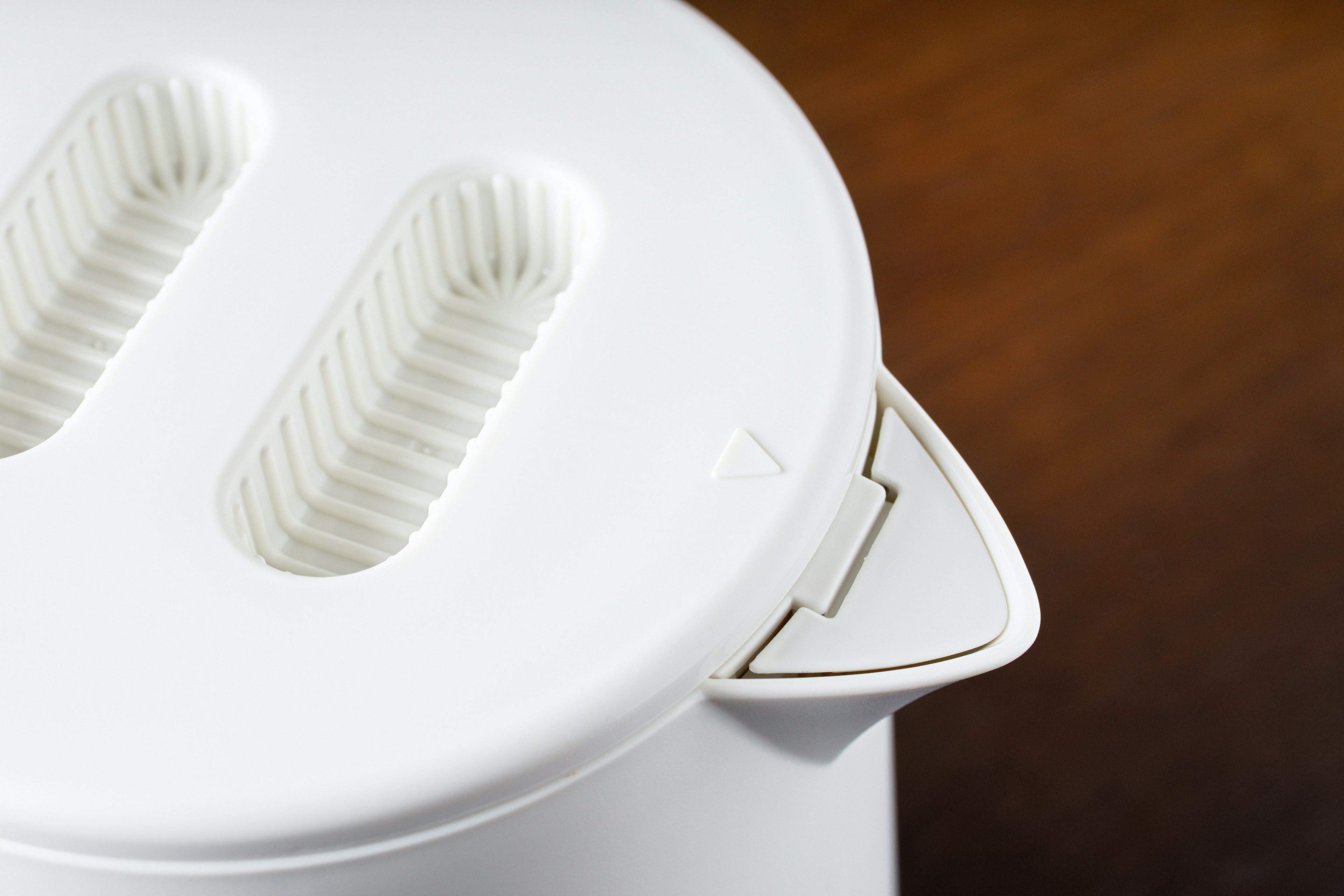 Close-up view of a white toaster featuring two slots and a minimalist design