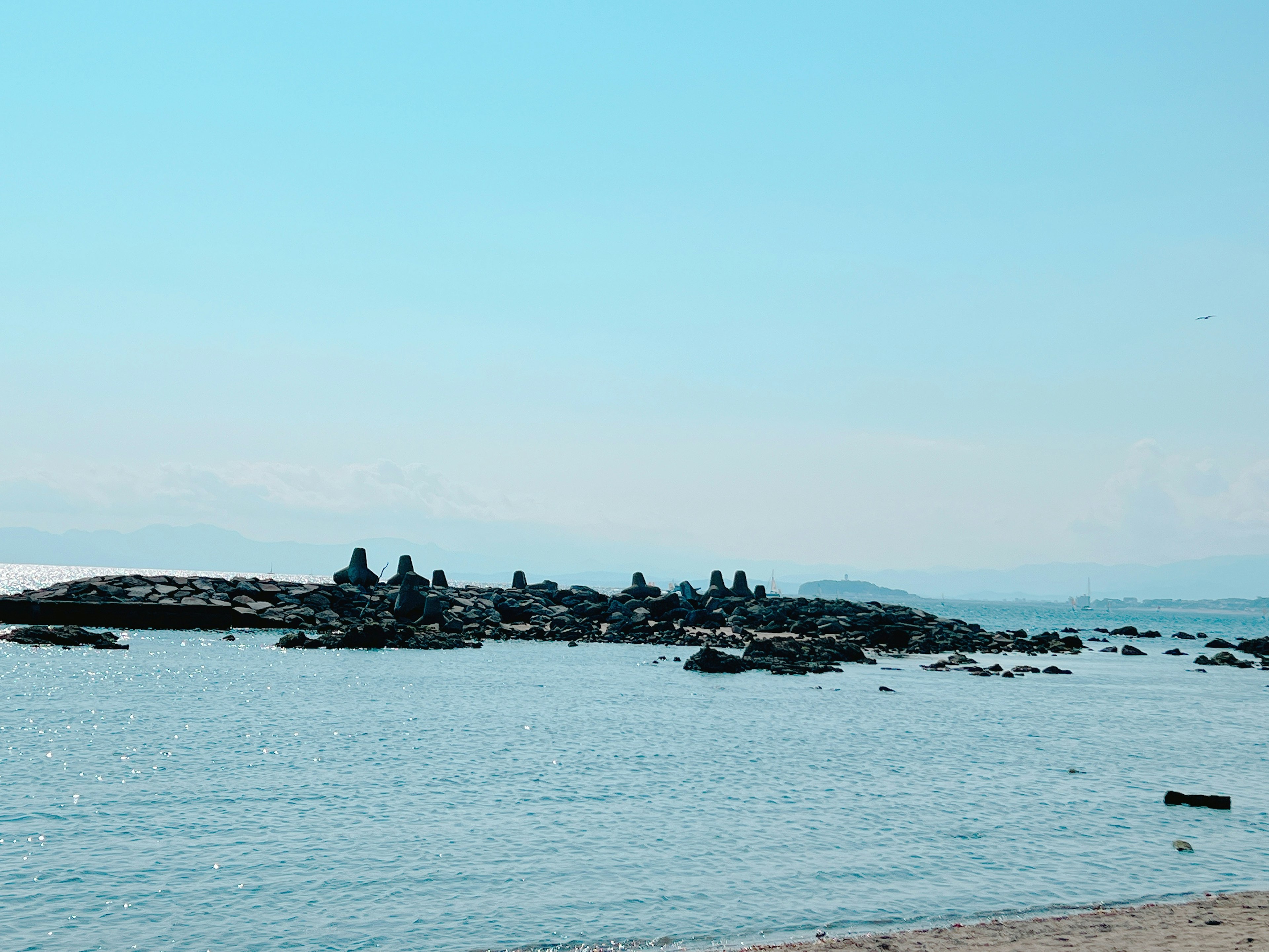 青い空と静かな海に浮かぶ岩の島