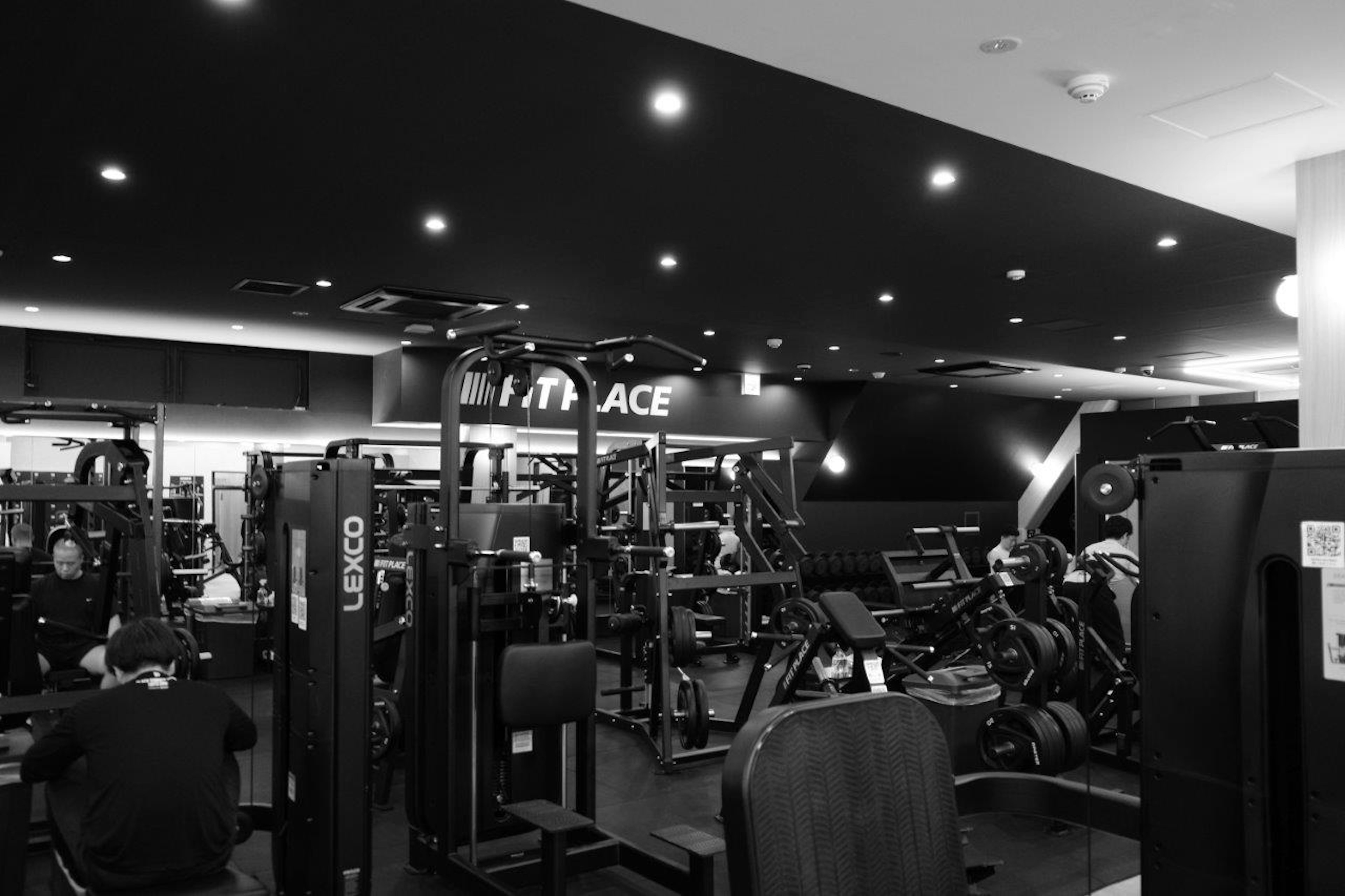 Interior of a gym, black and white color scheme, training machines arranged neatly