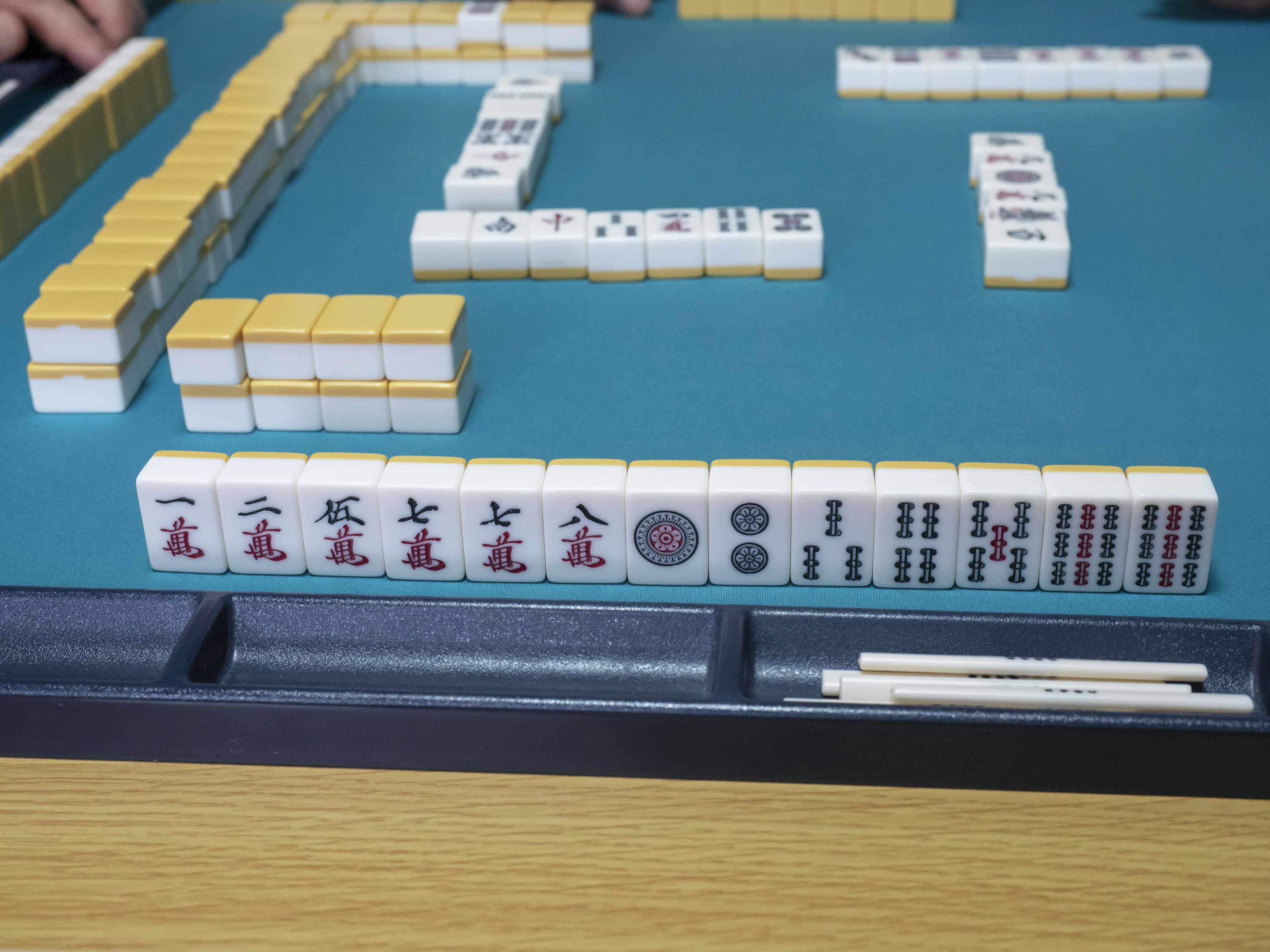 Mahjong-Steine auf einem grünen Spieltisch angeordnet