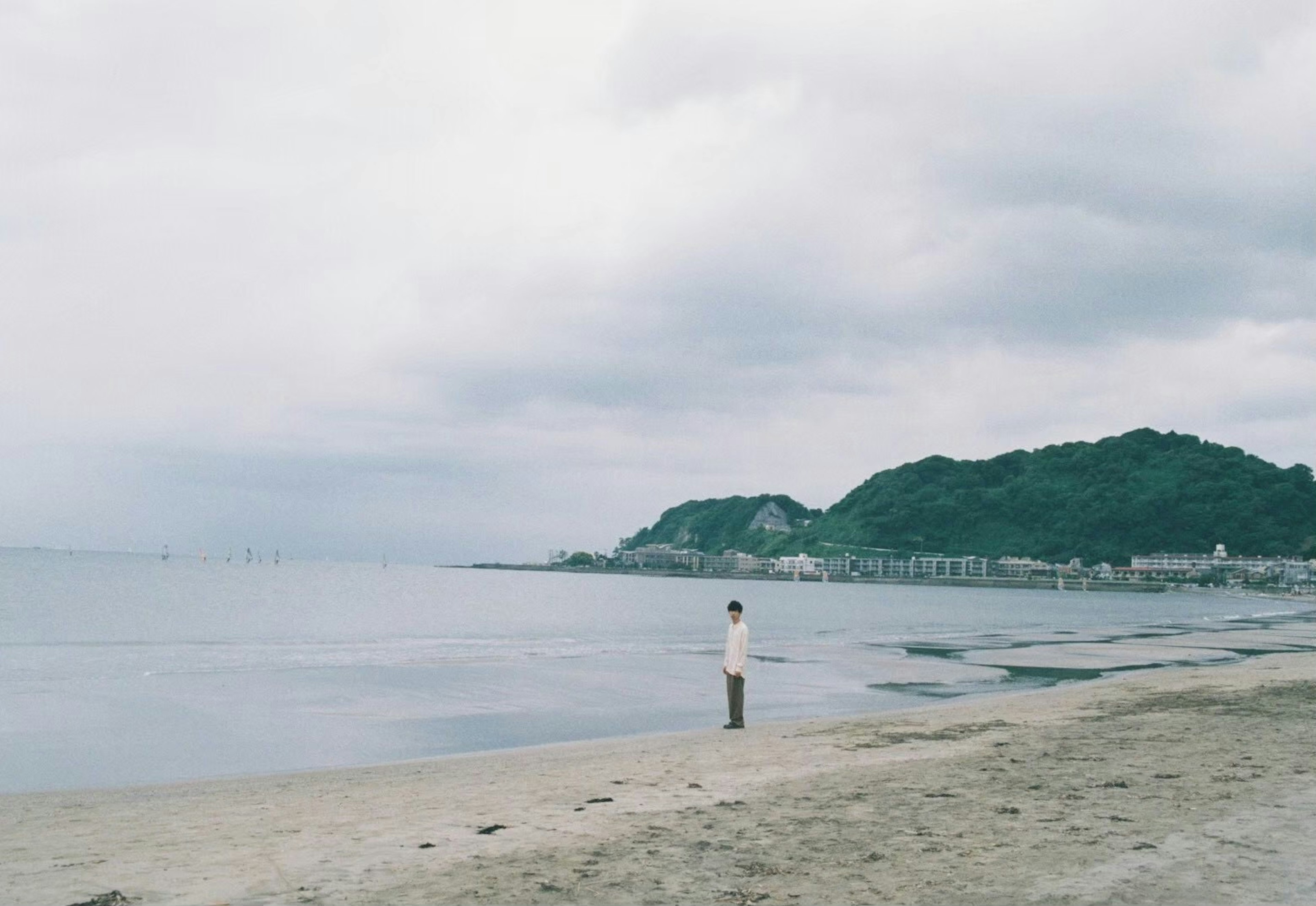 静かな海岸で遠くを見つめる人物の風景