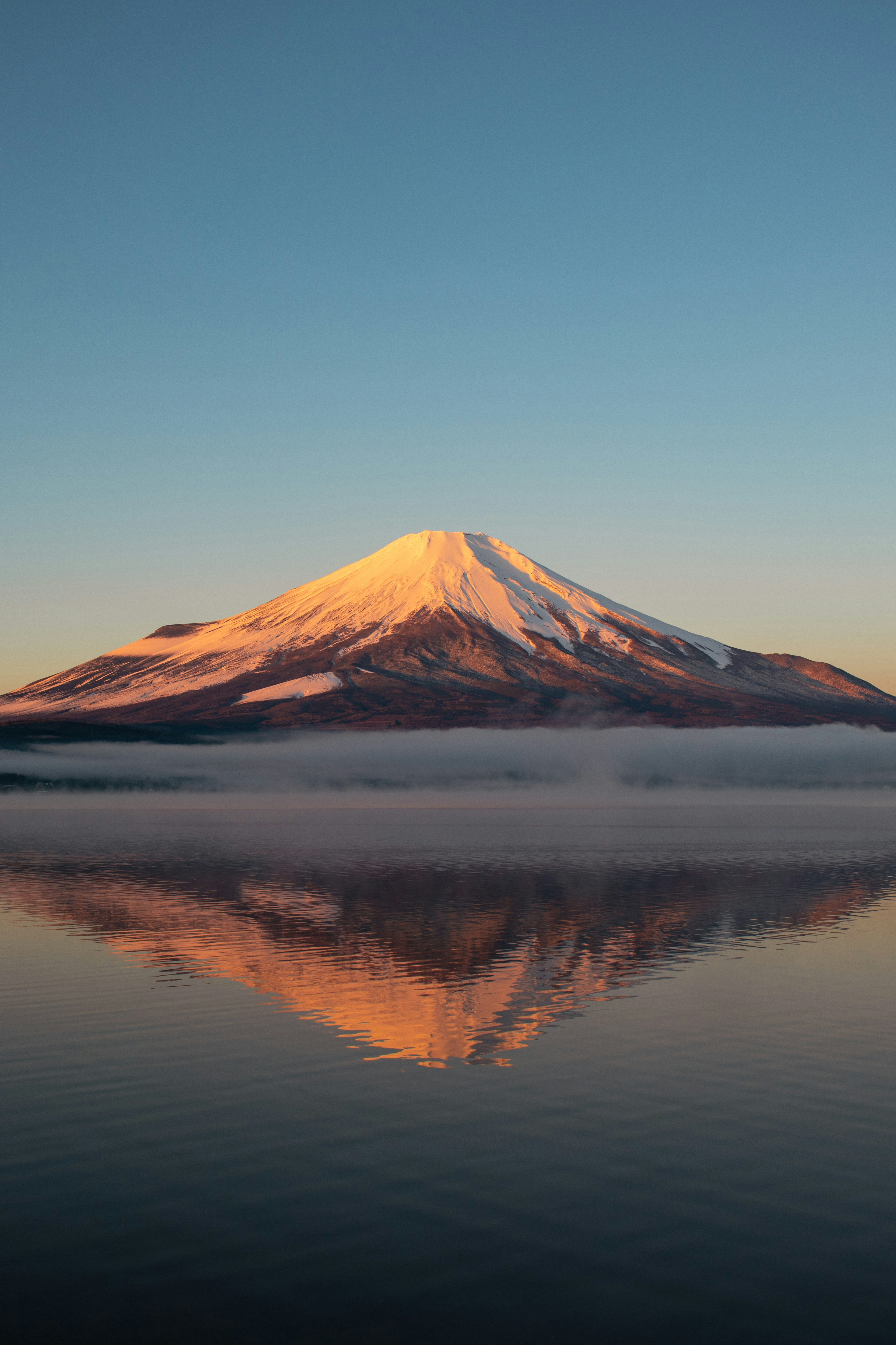 Hermosa vista matutina del Monte Fuji con la cima nevada reflejándose en el agua