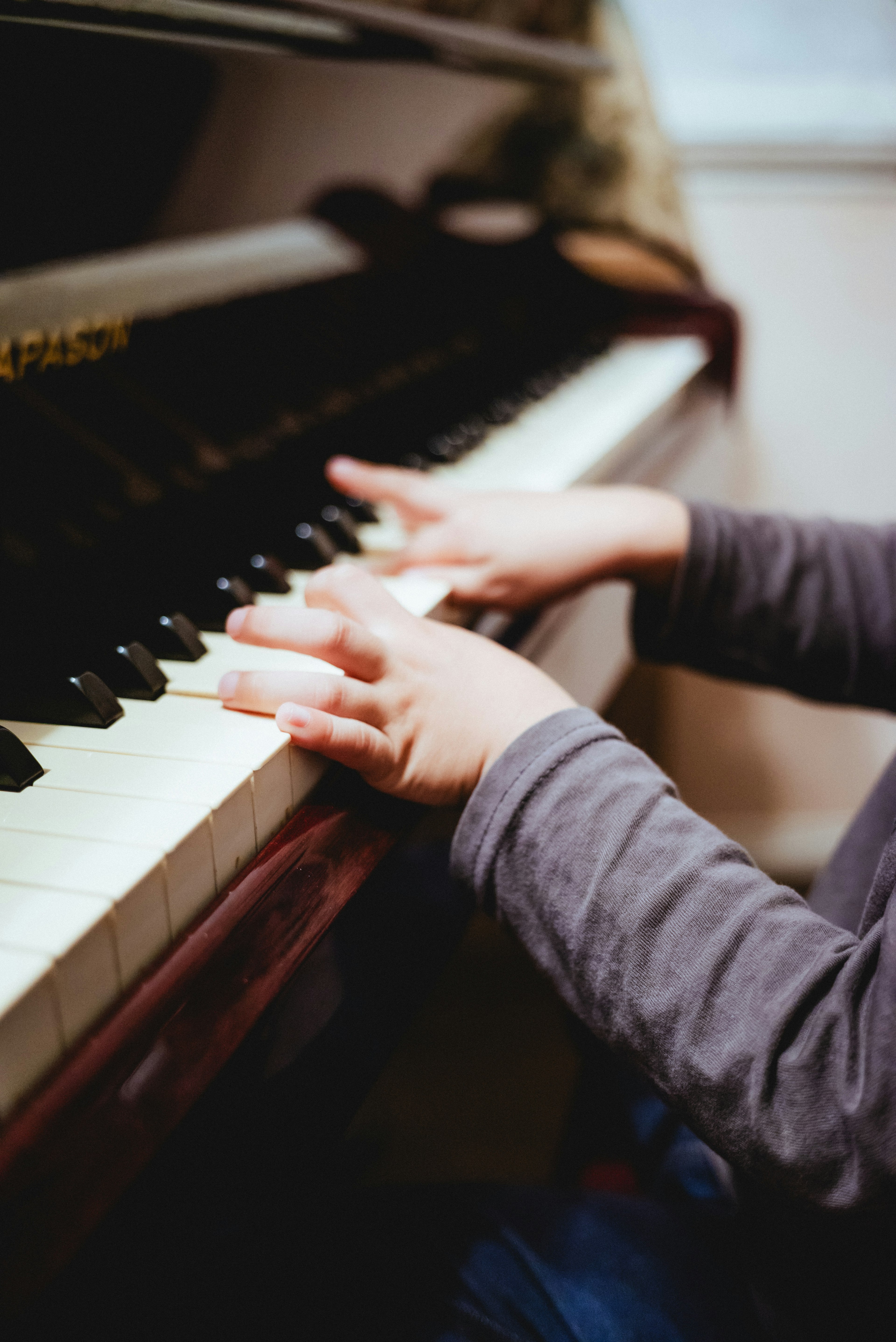 Un bambino che suona i tasti del pianoforte