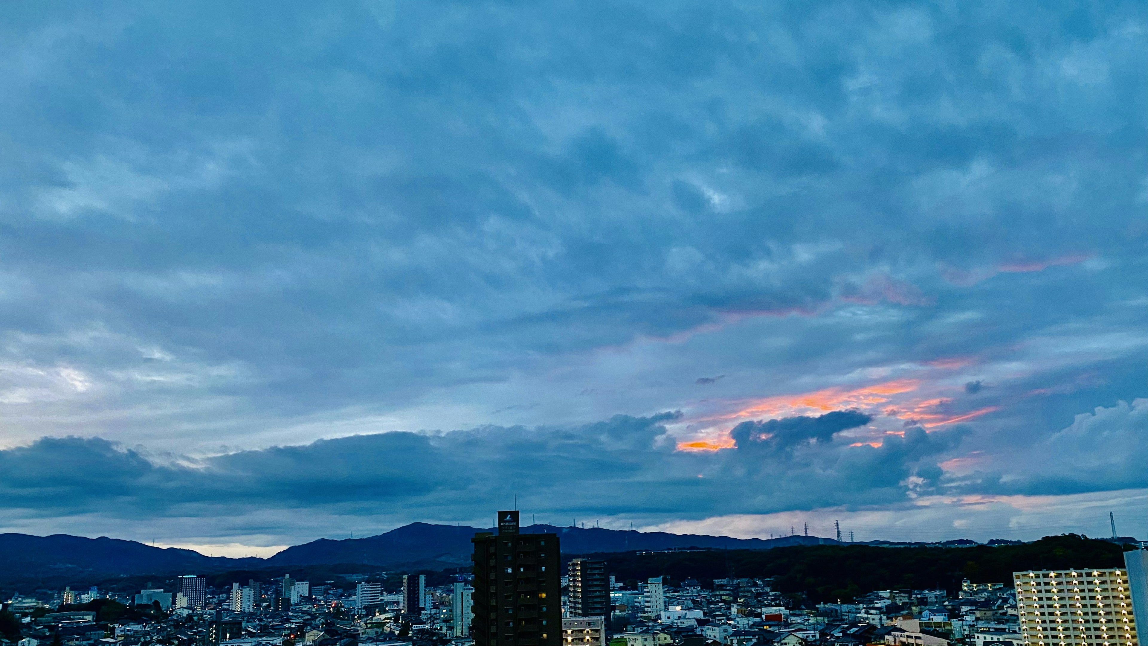 Paysage urbain sous un ciel bleu avec des nuages silhouette de montagnes en arrière-plan