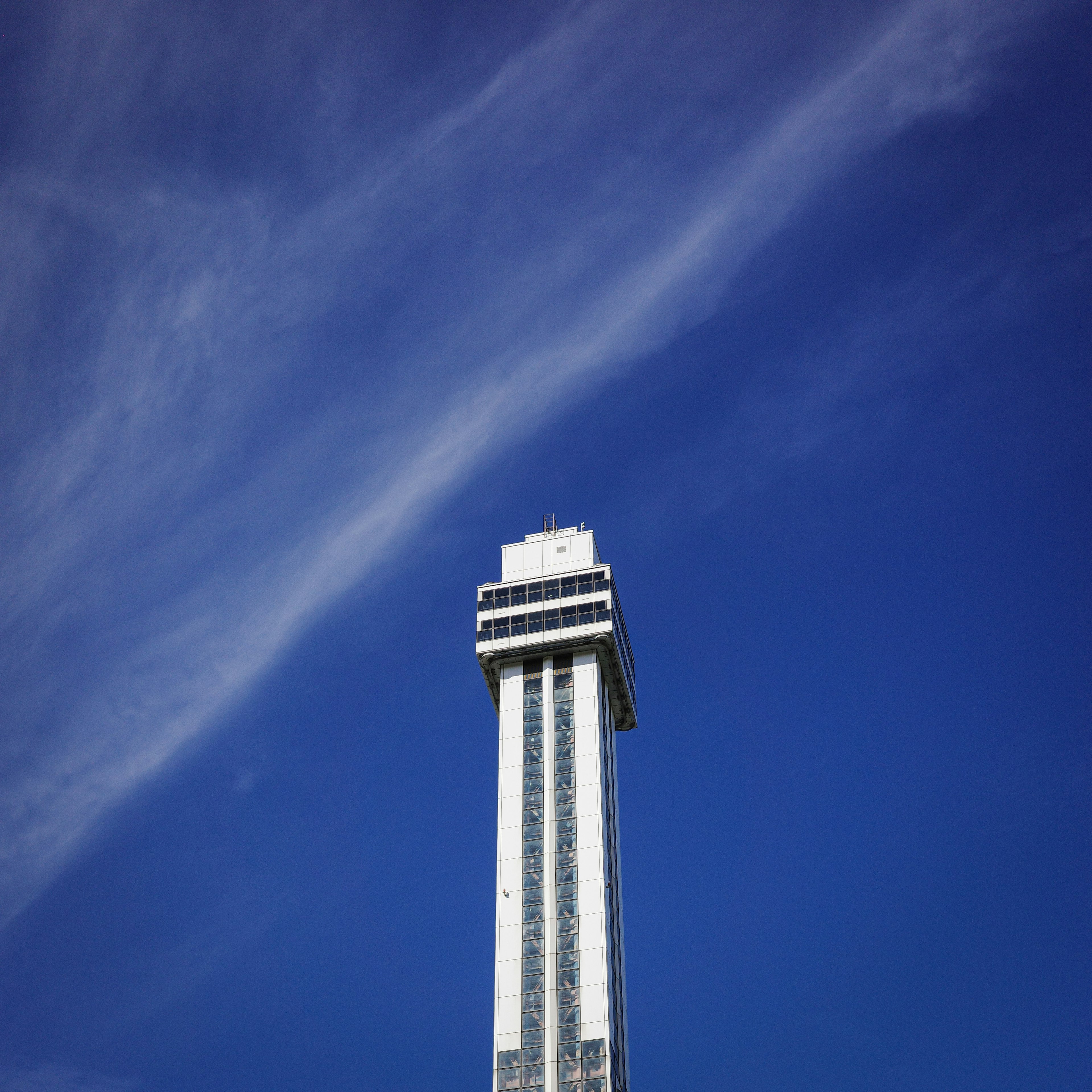 Bild eines hohen weißen Turms vor blauem Himmel