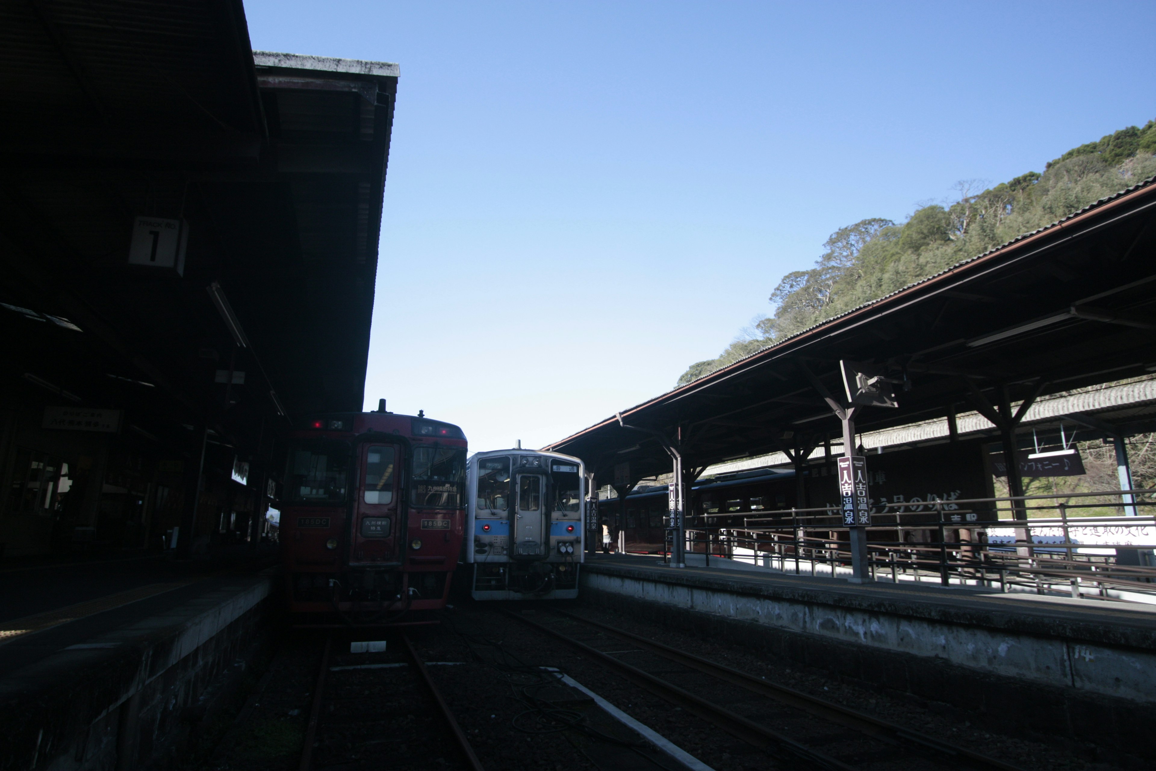 Kereta yang停 di platform stasiun di bawah langit biru yang cerah