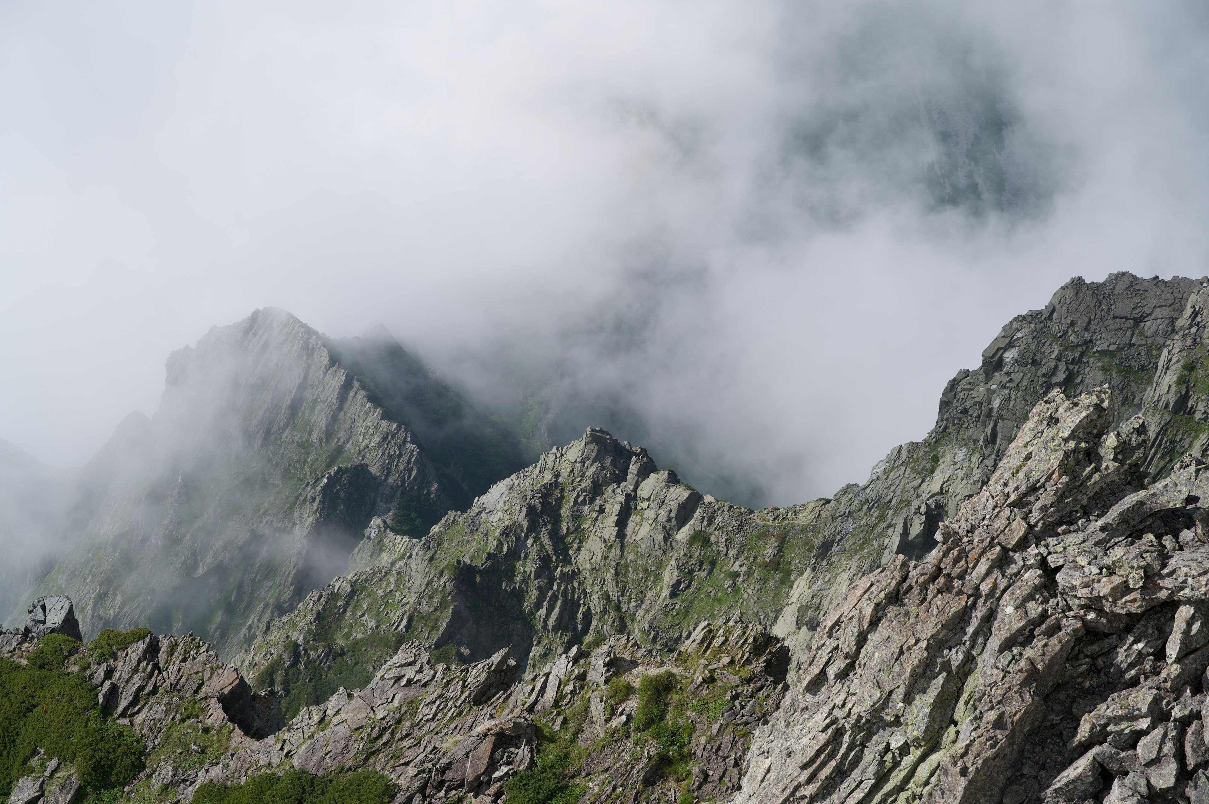 Berglandschaft in Nebel gehüllt mit felsigen Gipfeln