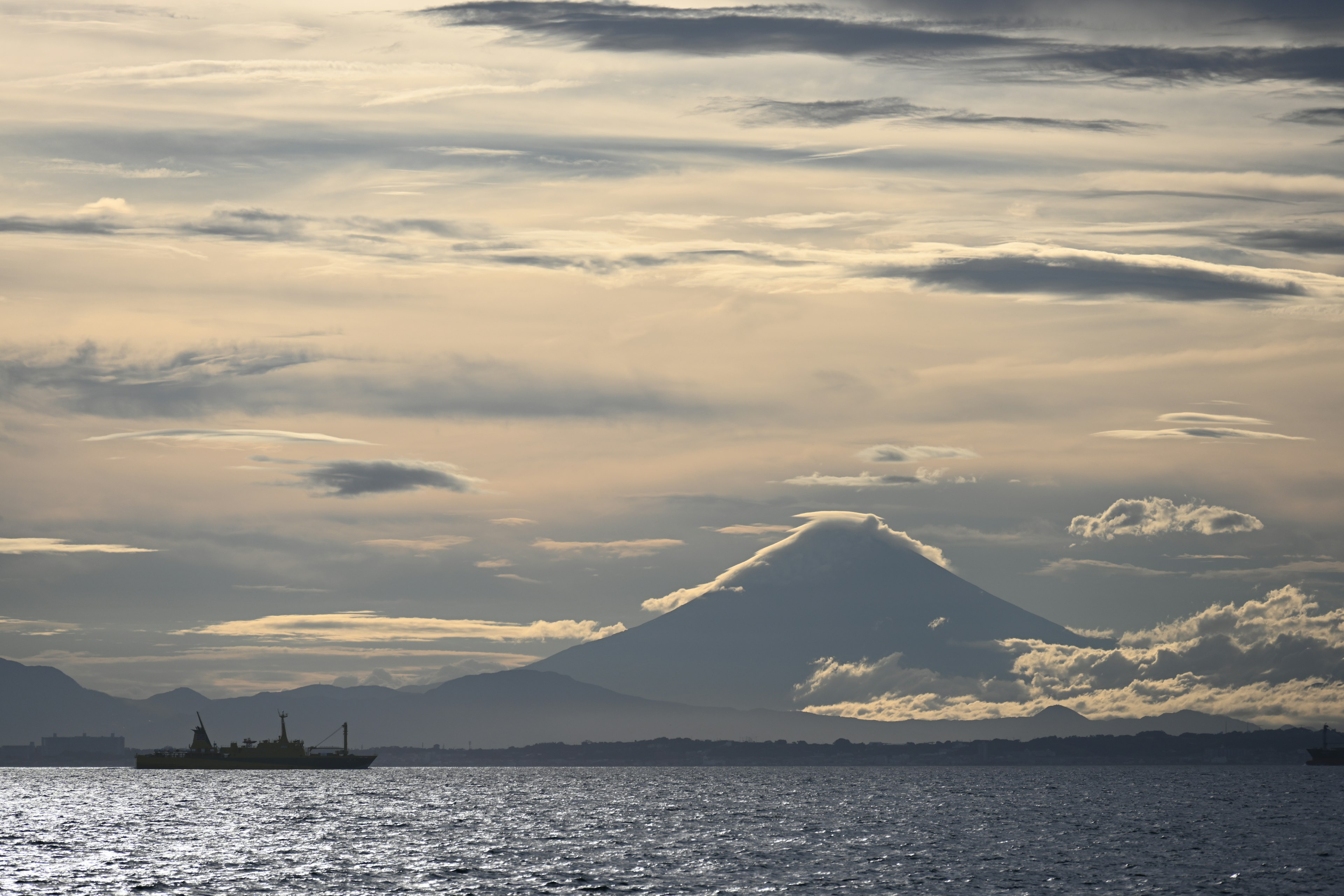 Una vista lontana di una nave sull'acqua con una montagna sullo sfondo