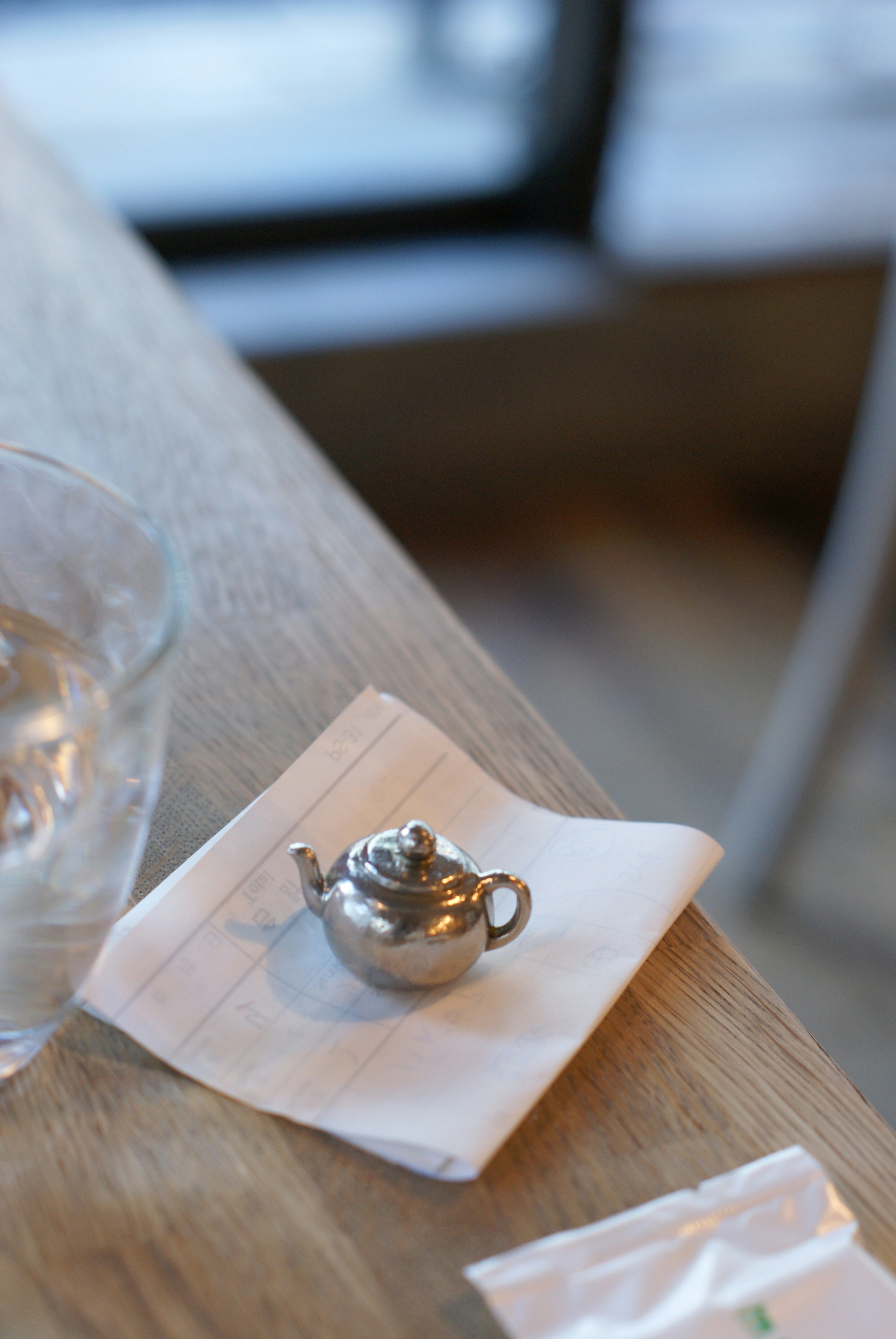 A small silver teapot placed on a napkin