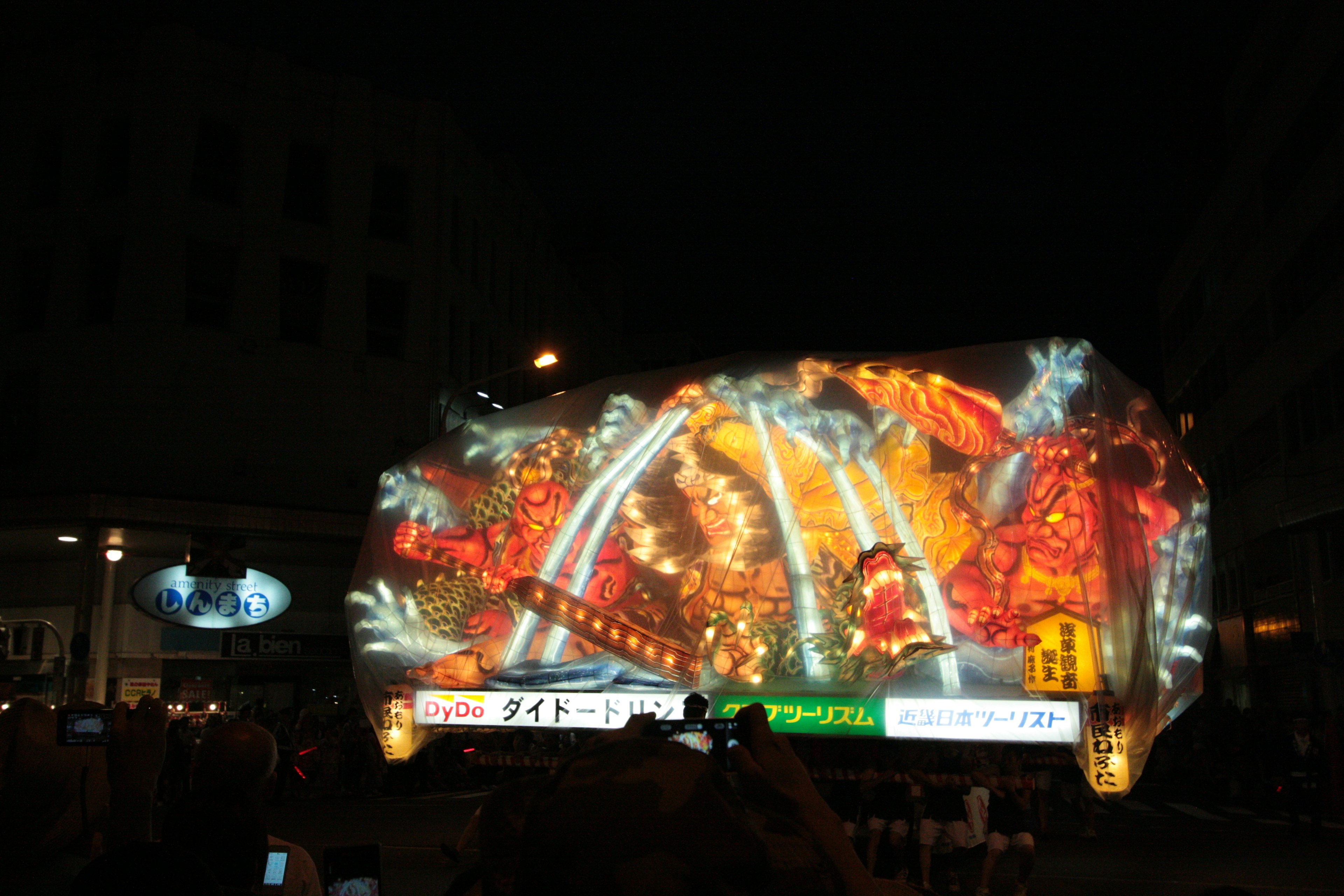 Colorful light display projected onto a building at night showcasing festive elements