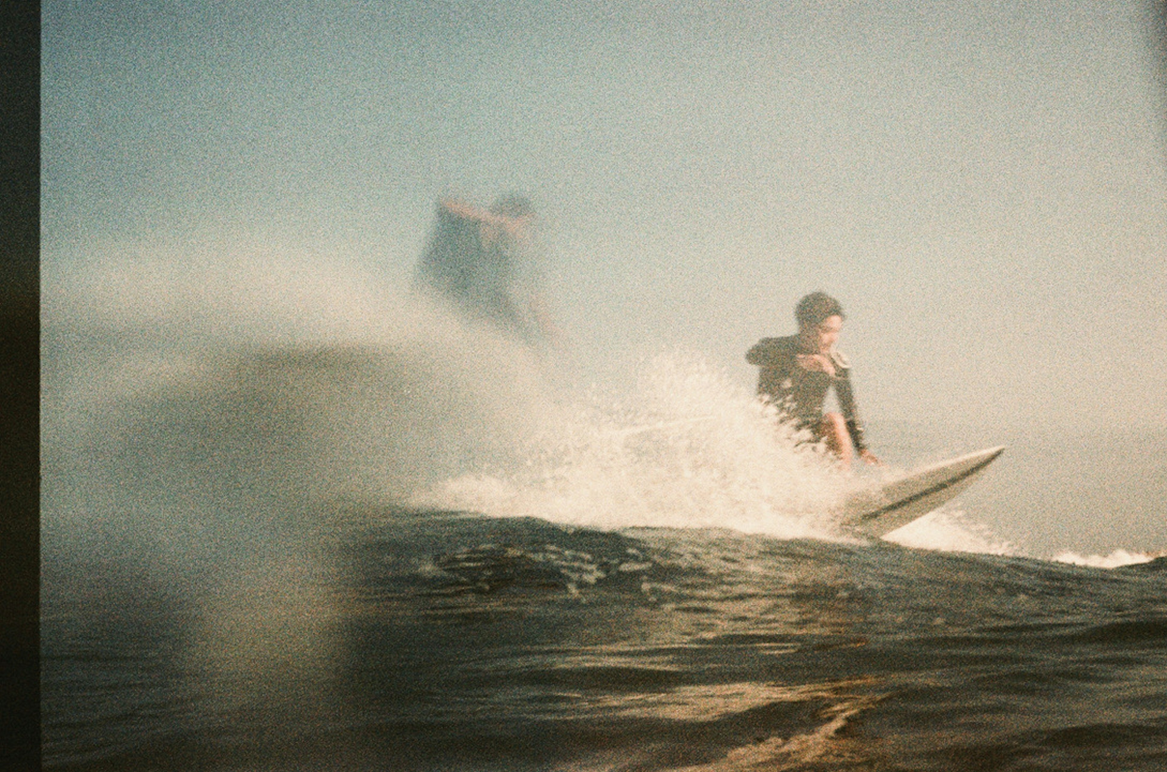 Un uomo che fa surf su un'onda con schizzi intorno