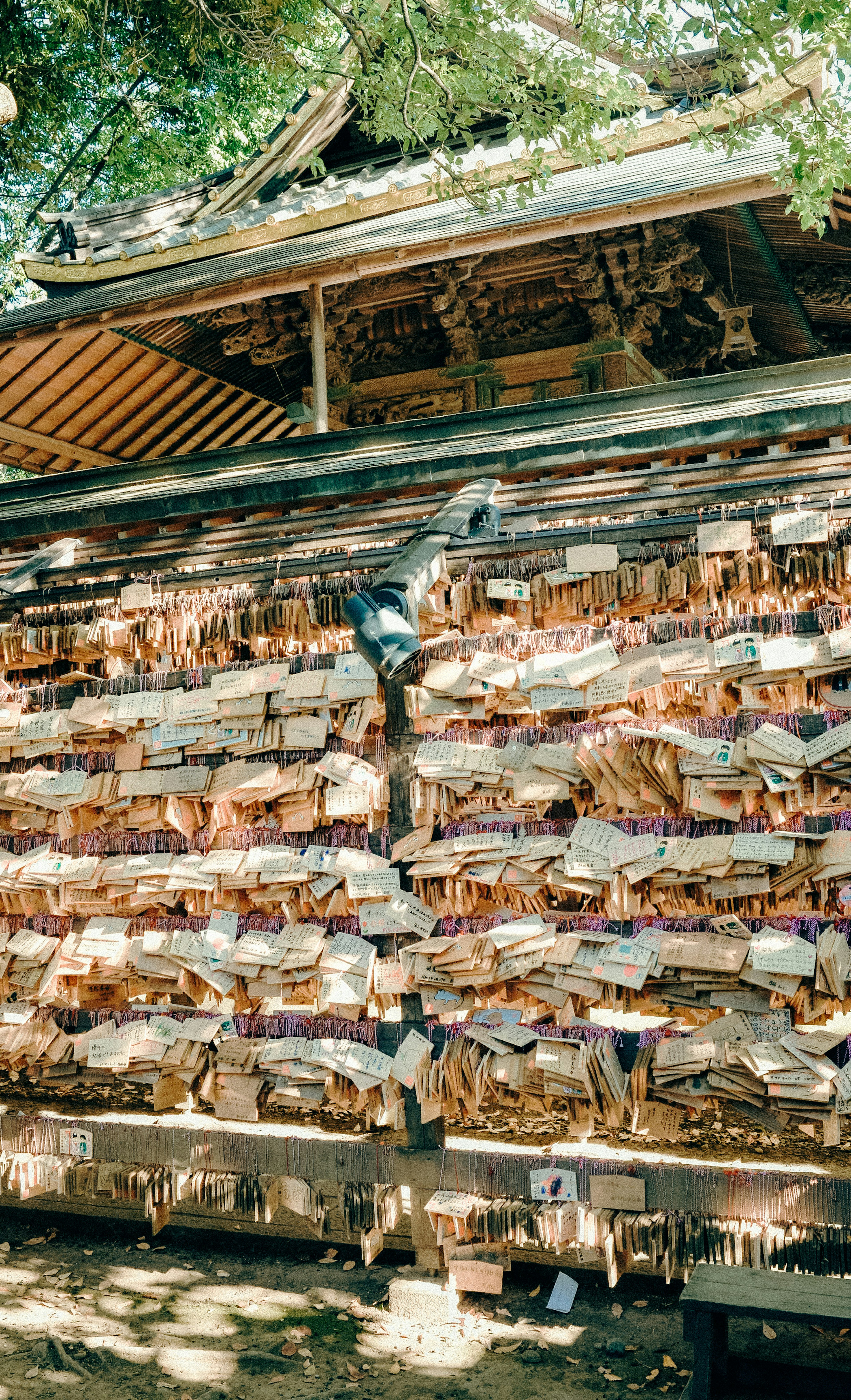 Papan kayu dan kertas berwarna menggantung di dinding kuil