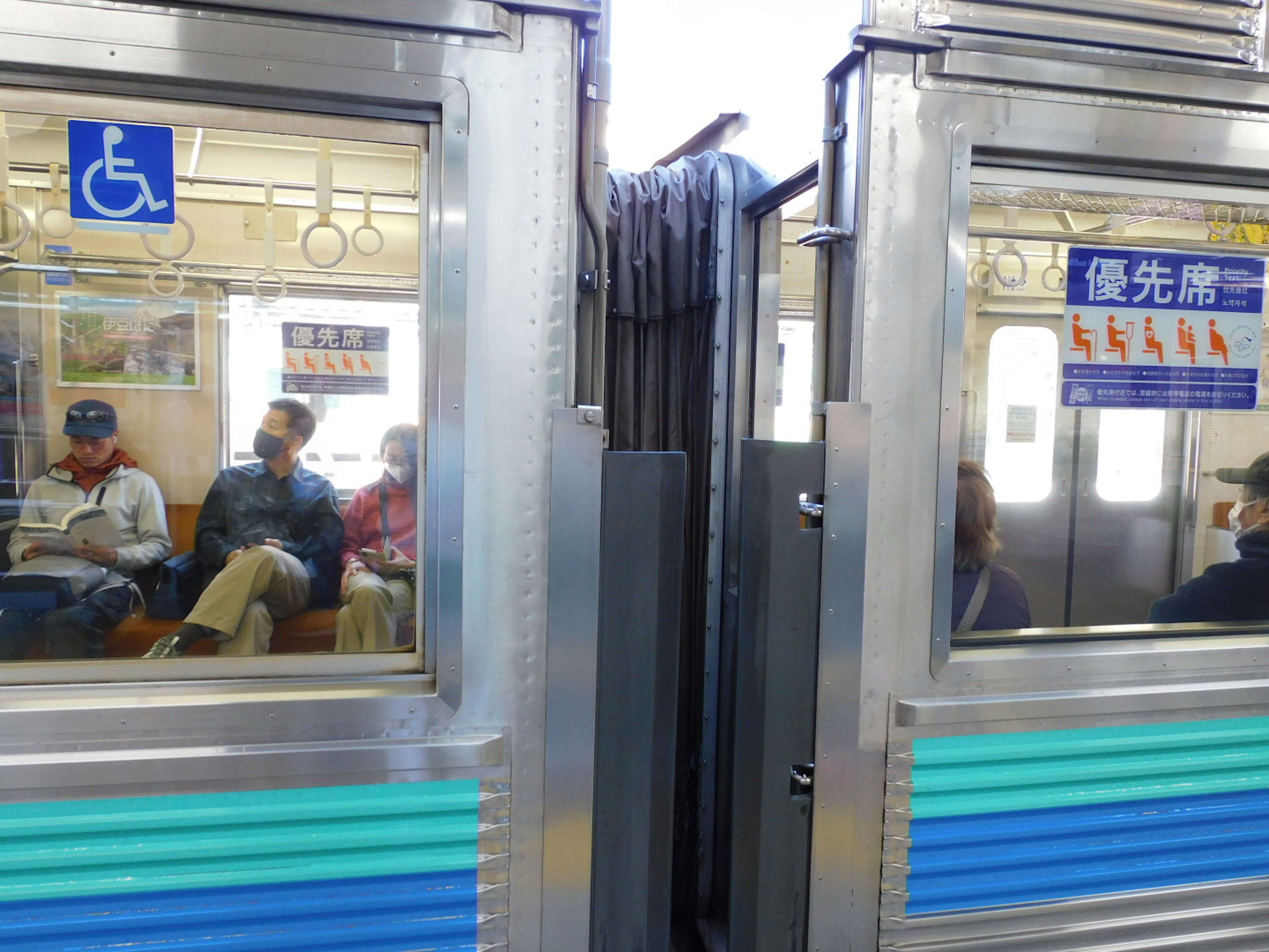 Passengers inside a train compartment visible between two doors