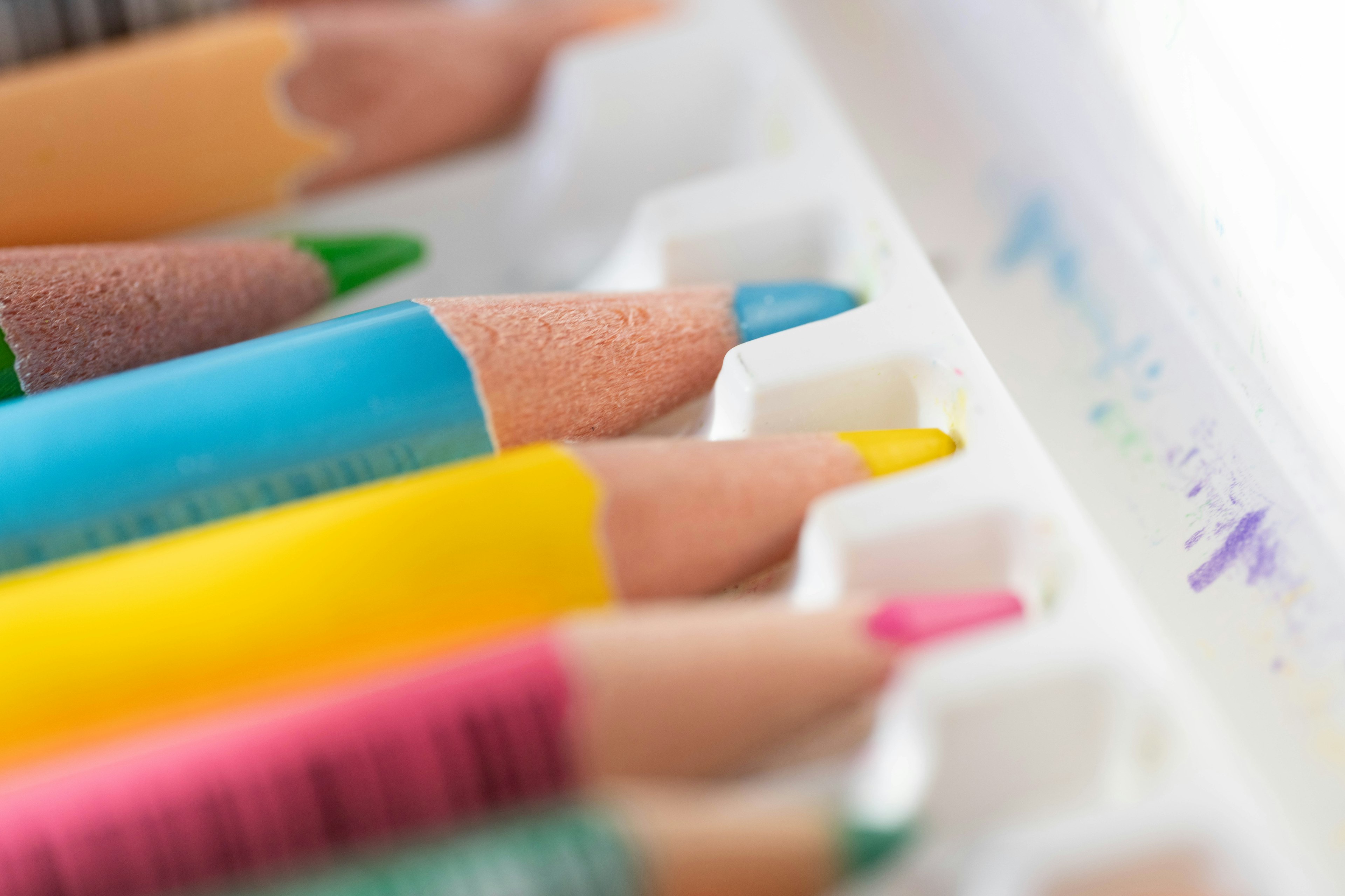 A close-up of colorful colored pencils arranged in a tray