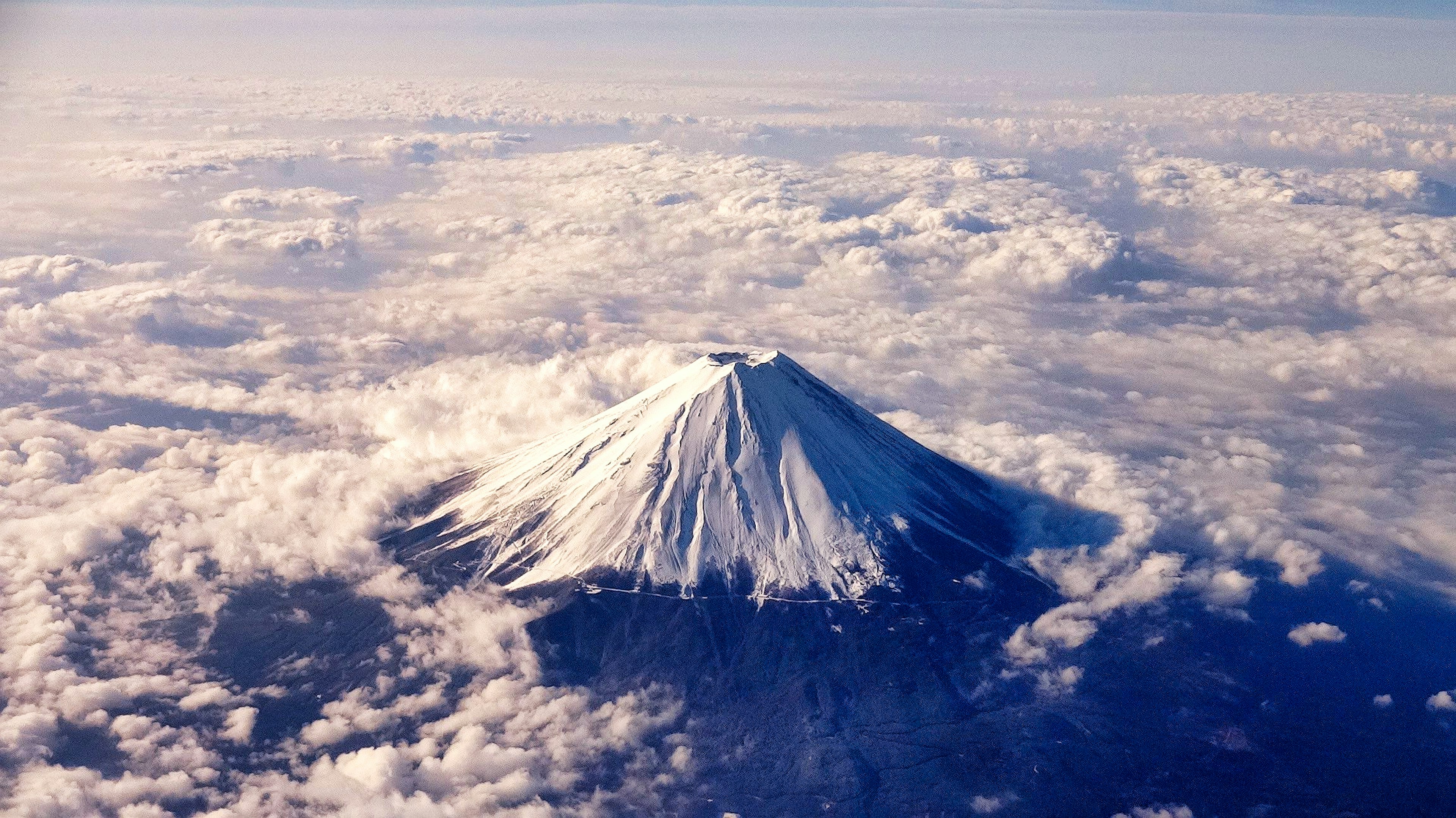 雪覆蓋的富士山峰高聳在雲層之上