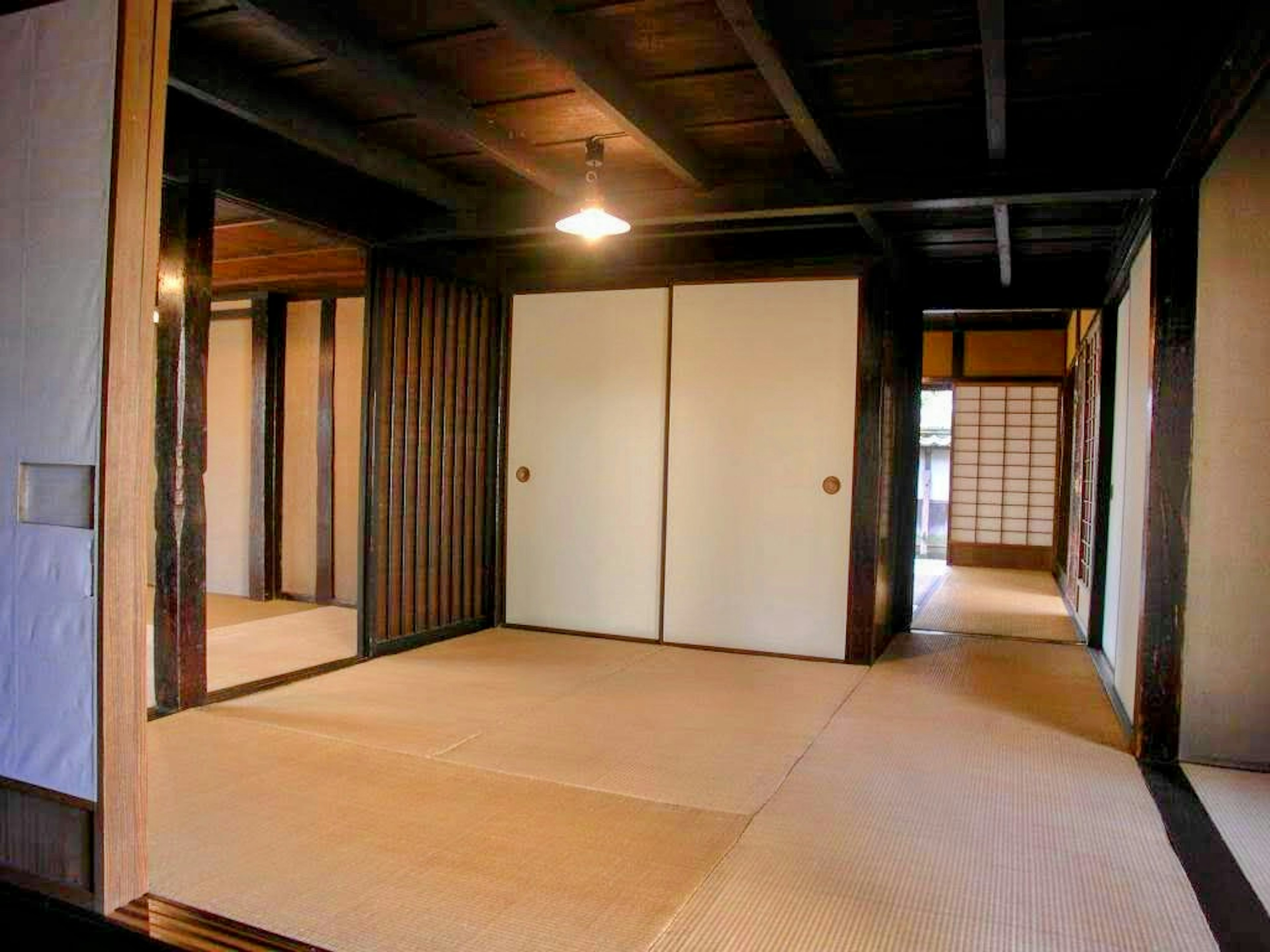 Interior simple de una habitación japonesa con suelo de tatami puertas correderas vigas y paredes de madera