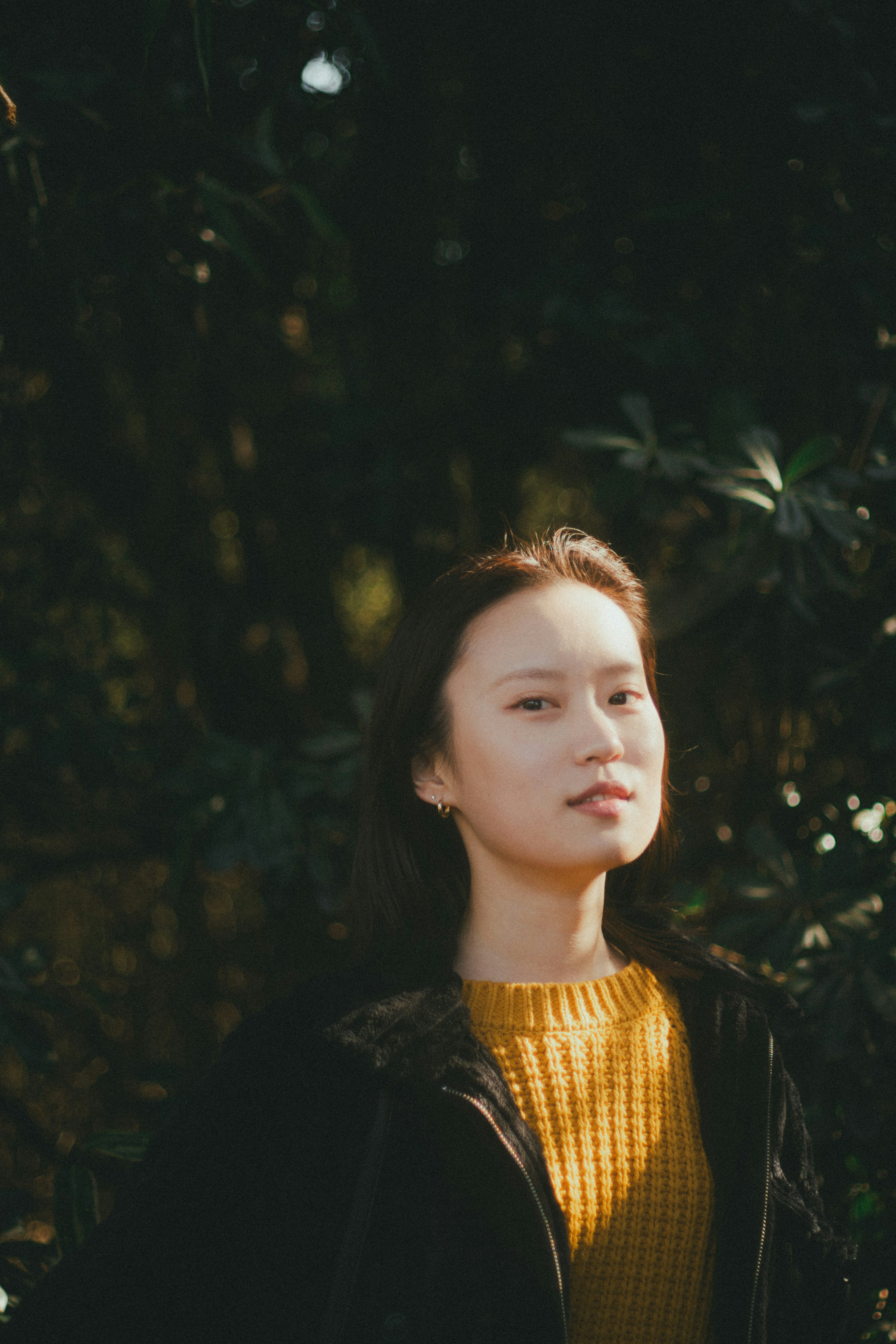 Portrait d'une femme devant un fond vert portant un pull jaune