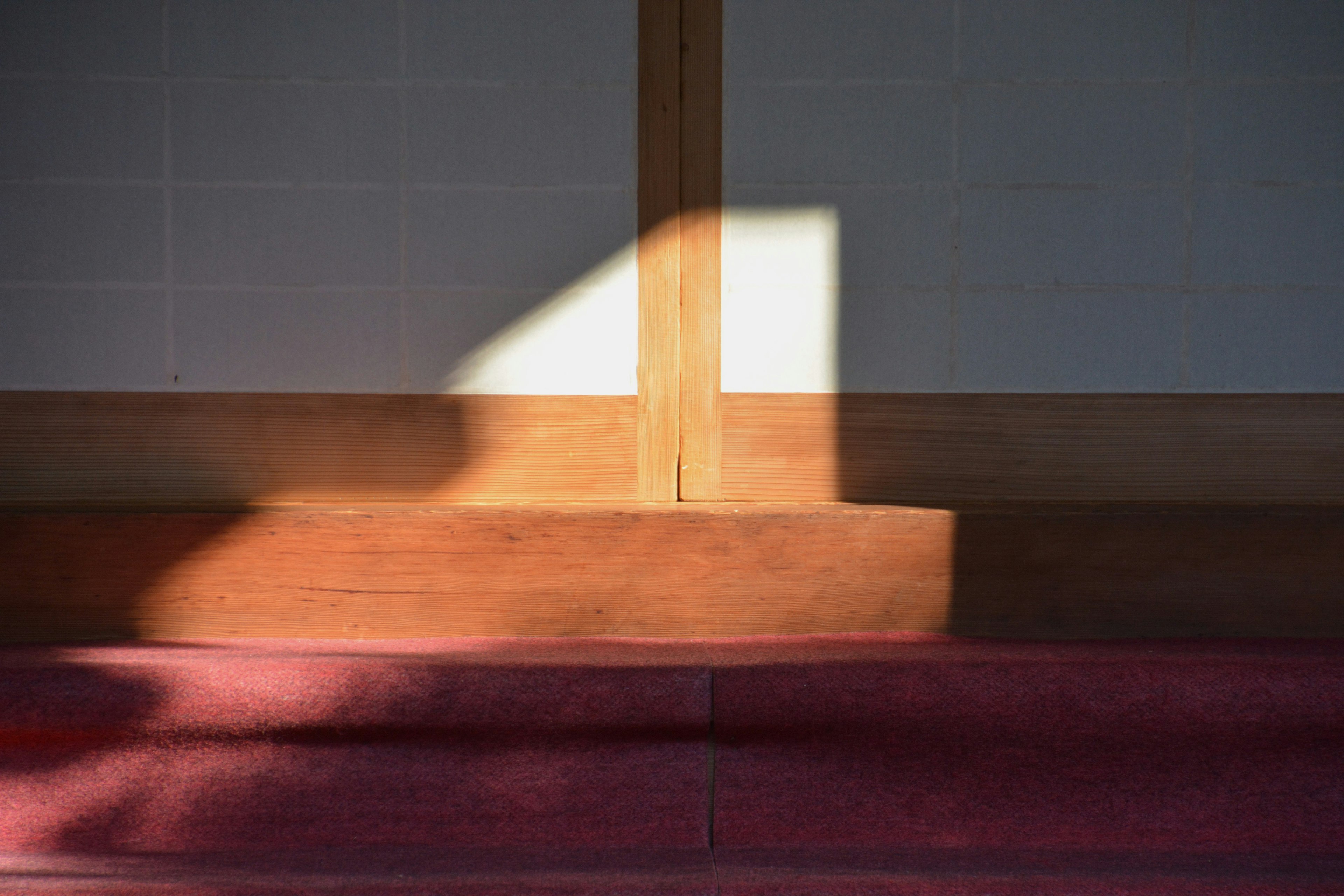 Intérieur simple avec des ombres projetées par du bois et des murs blancs