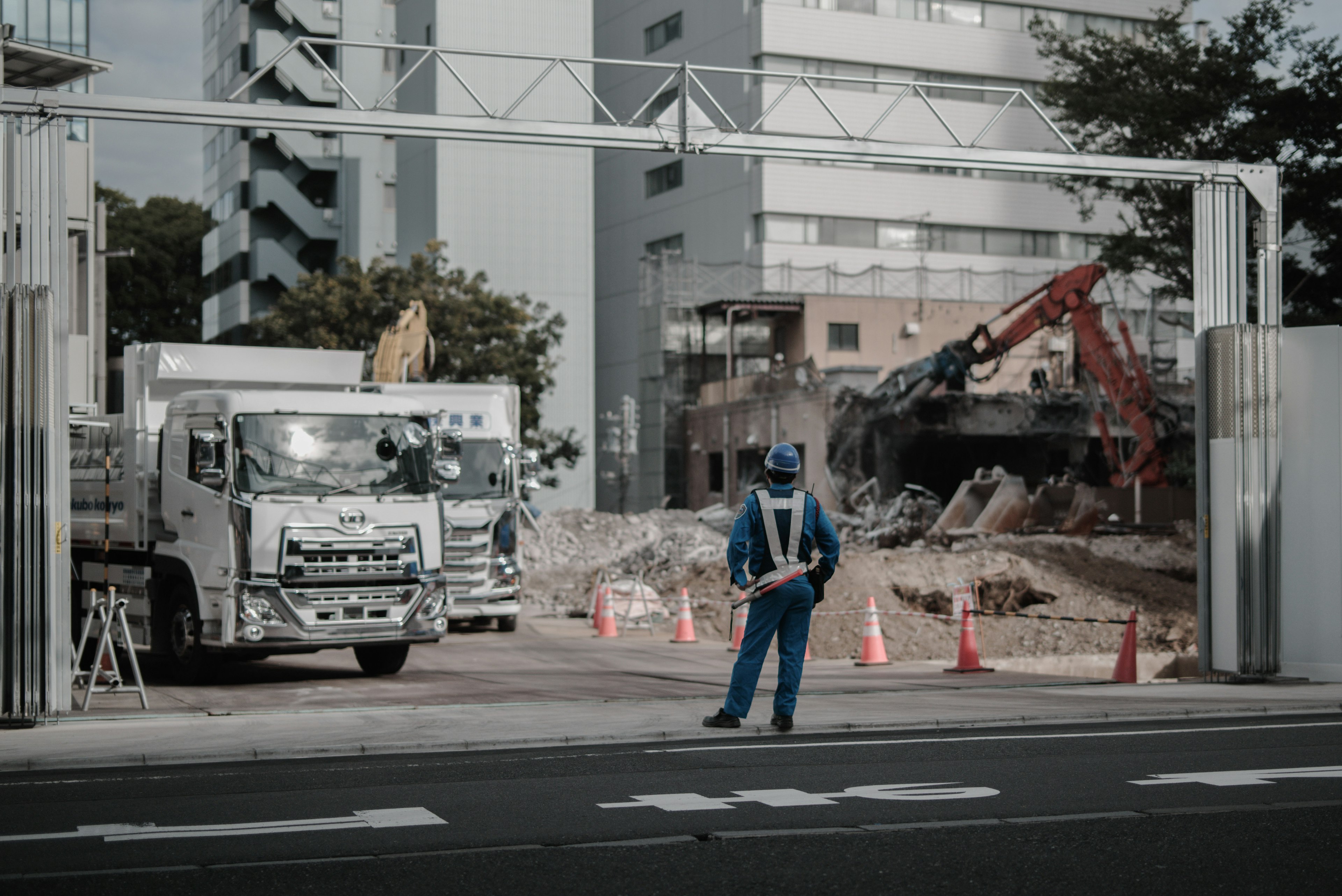 Chantier de construction avec un ouvrier debout et des machines lourdes en arrière-plan