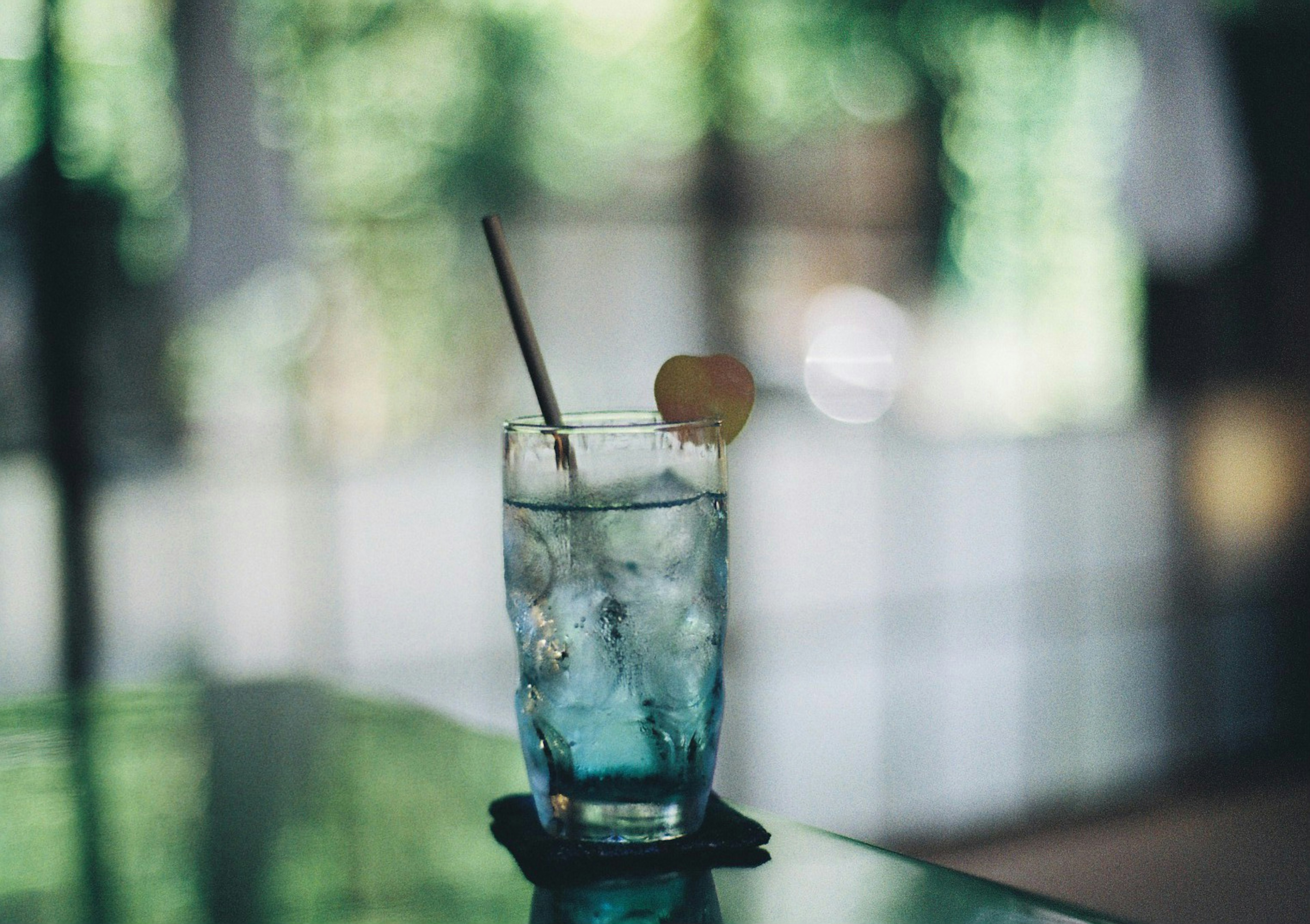 Un cocktail bleu dans un verre avec de la glace sur une table